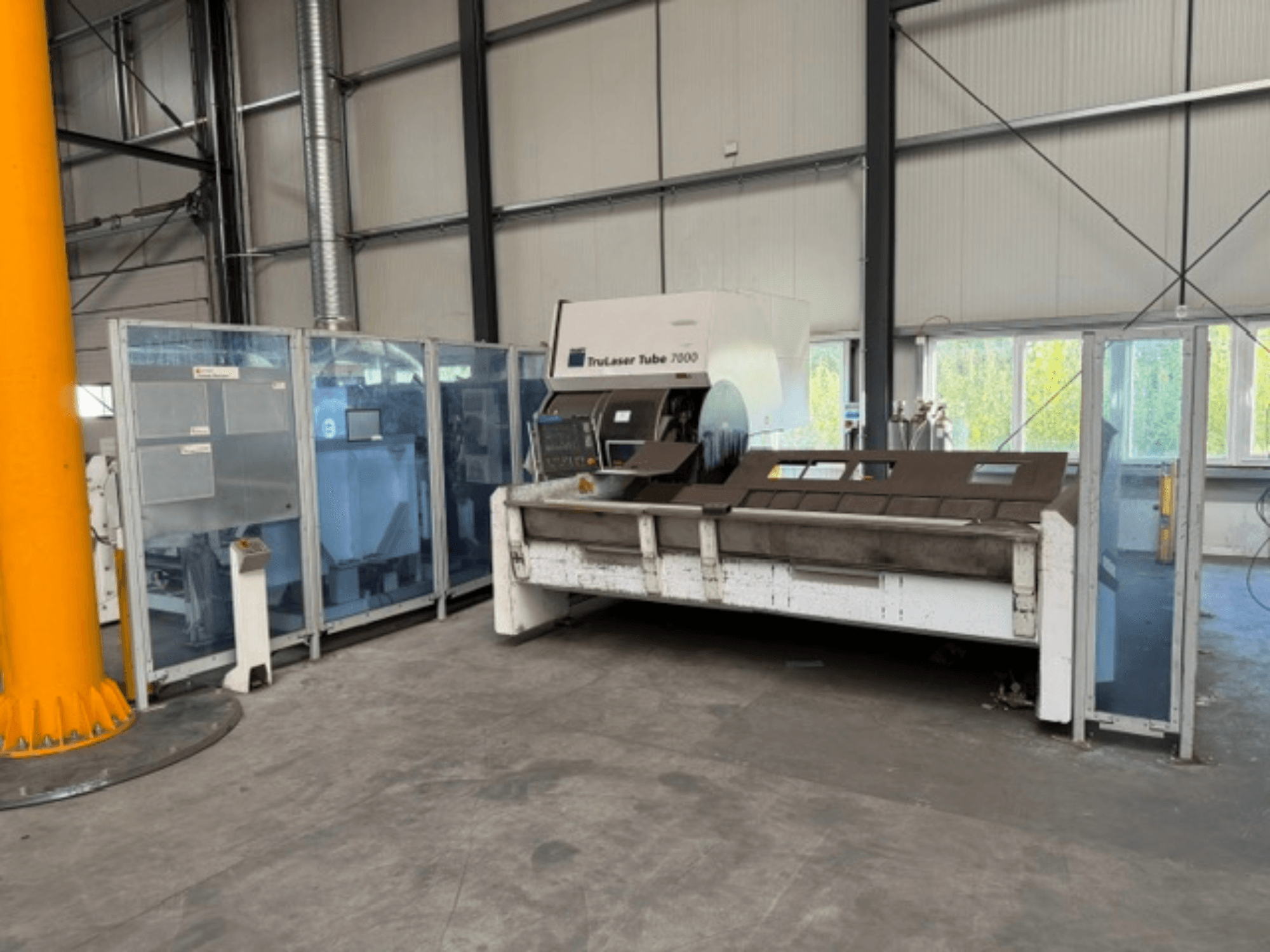TruLaser Tube 7000 van TRUMPF, vooraanzicht van een buissnijmachine in een goed verlichte industriële omgeving, waarbij de bedieningselementen zichtbaar zijn.