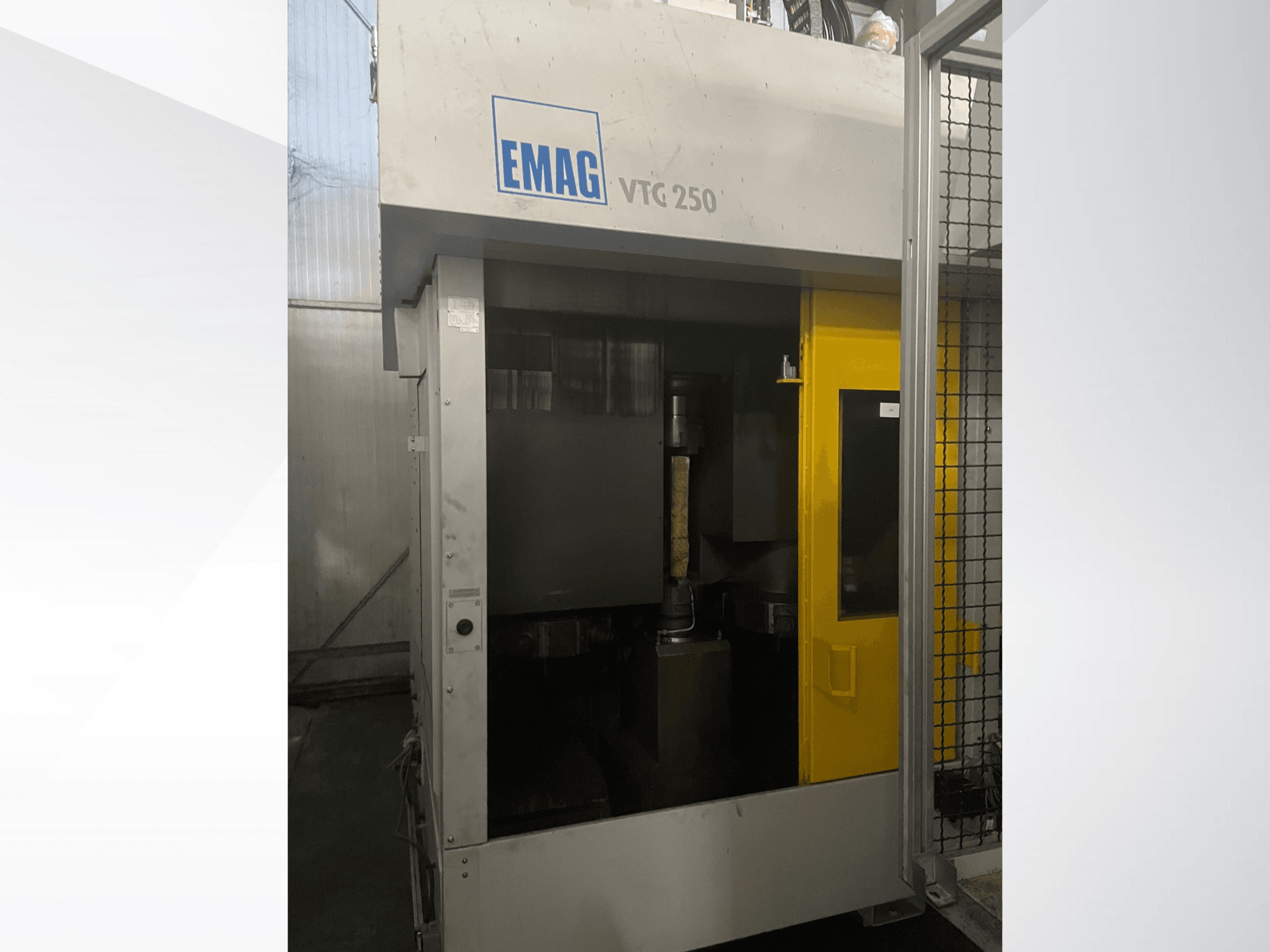 EMAG VTC 250 verticaal bewerkingscentrum in vooraanzicht, met een gele deur en een zichtbaar snijgereedschap in de kamer.