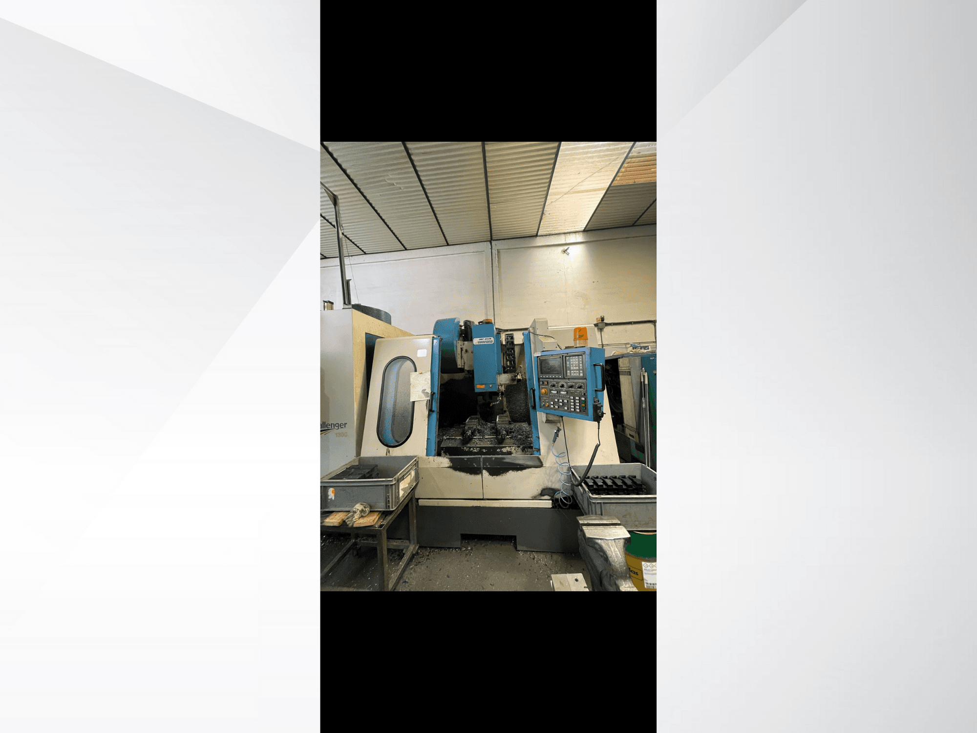 CNC machine, model Challenger 1500, zijaanzicht met bedieningspaneel en werkruimte met metaalschilfers.
