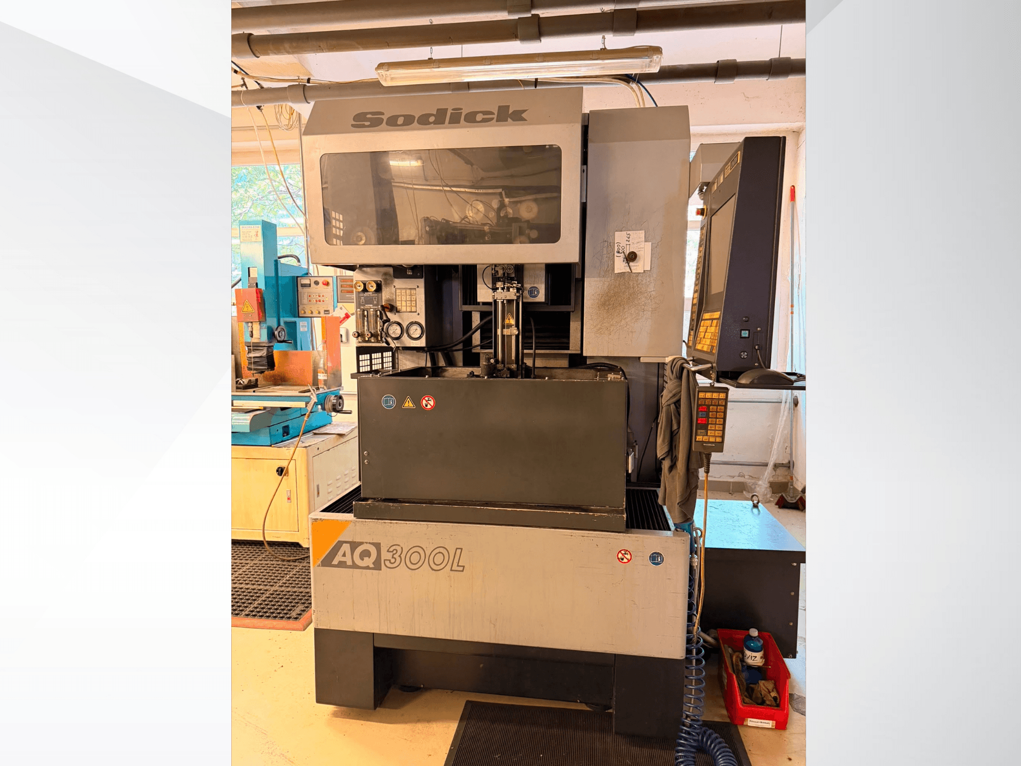 Sodick AQ300L draadvonkmachine, vooraanzicht, met zichtbaar bedieningspaneel, werkgebied en veiligheidsindicatoren.