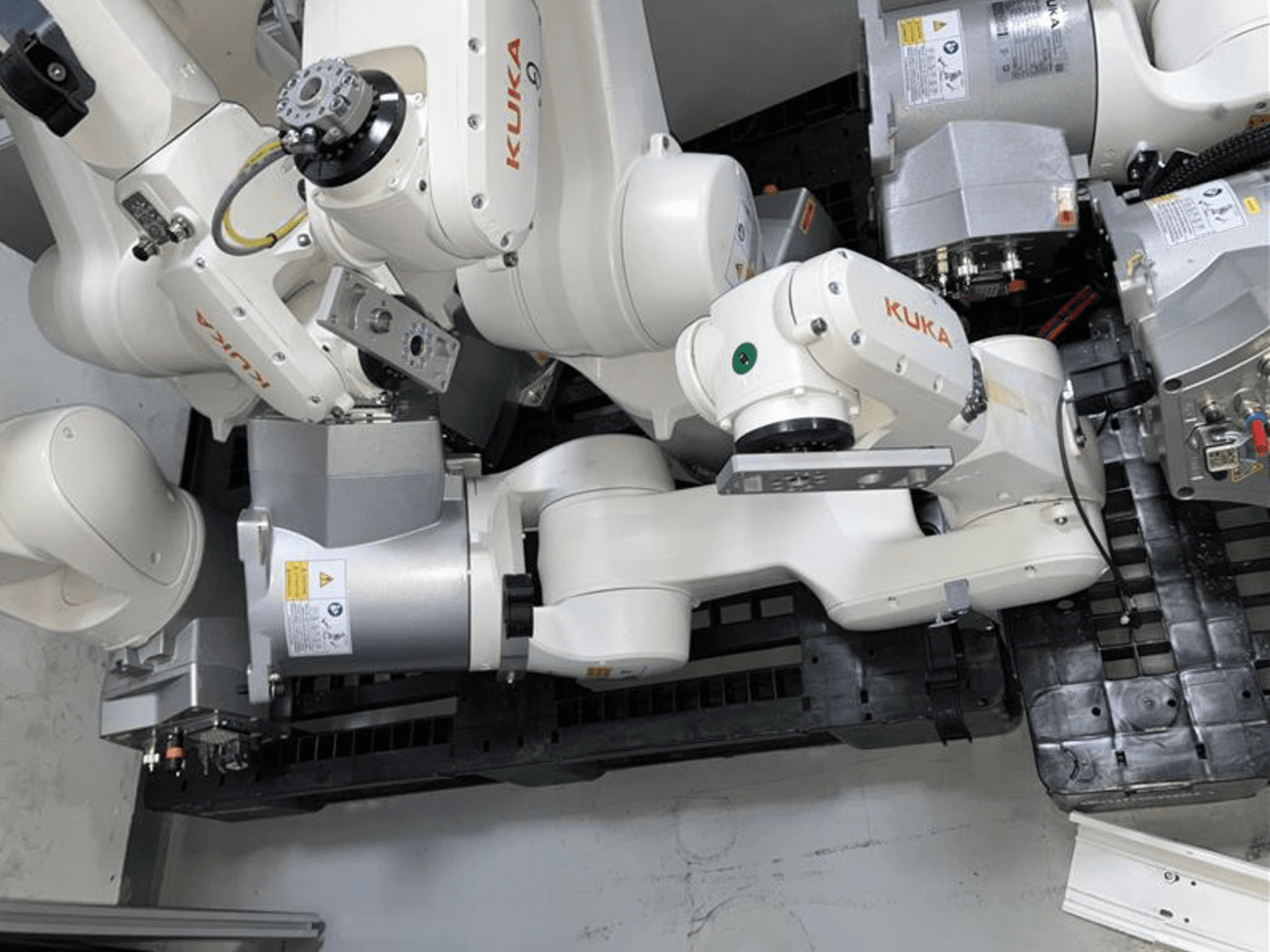KUKA KR 6 R900 CR robotarm in bovenaanzicht, met meerdere gewrichten en motoren, gemonteerd op een zwarte basis met kabels.