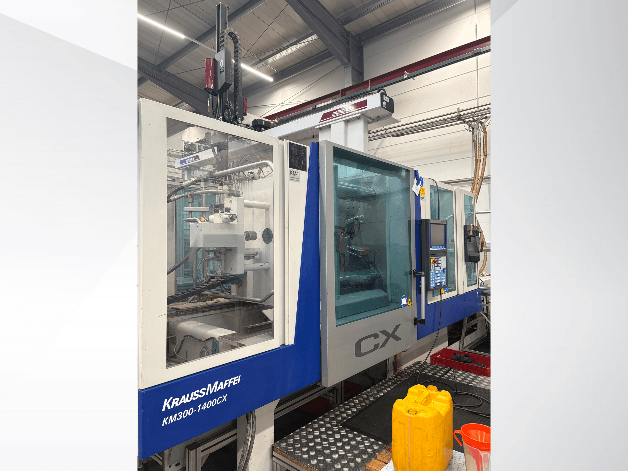 Krauss Maffei 300-1400 CX hydraulische spuitgietmachine, vooraanzicht met bedieningspaneel en doorzichtige beschermkap.