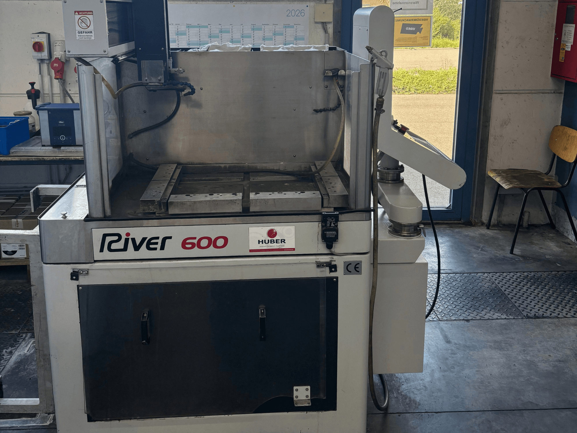 HUBER River 600 CNC-zinkvonkmachine, vooraanzicht, met een gedeeltelijk open werkruimte en bedieningspaneel.