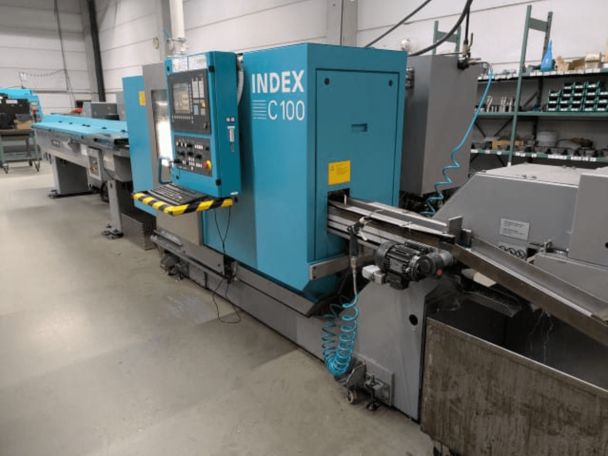 Index C100 horizontale draaibank, zijaanzicht; voorzien van een bedieningspaneel, een toevoersysteem en een opvangbak voor metaalkrullen.