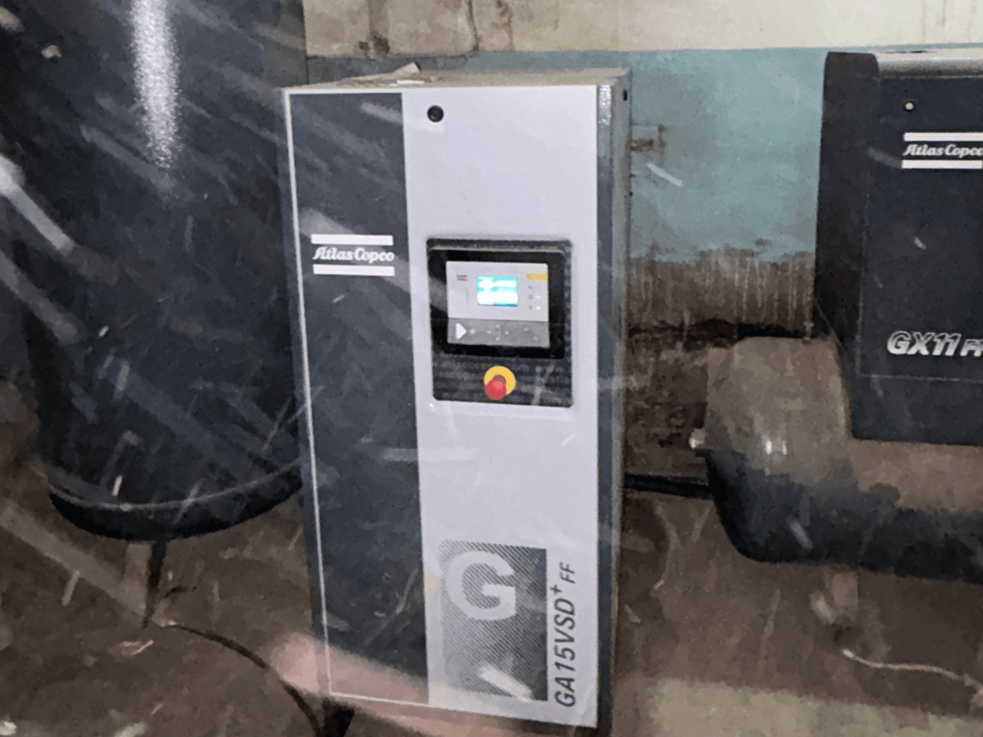 Atlas Copco GA15VSD+FF-luchtcompressor, vooraanzicht, inclusief bedieningspaneel met display en rode noodstopknop.