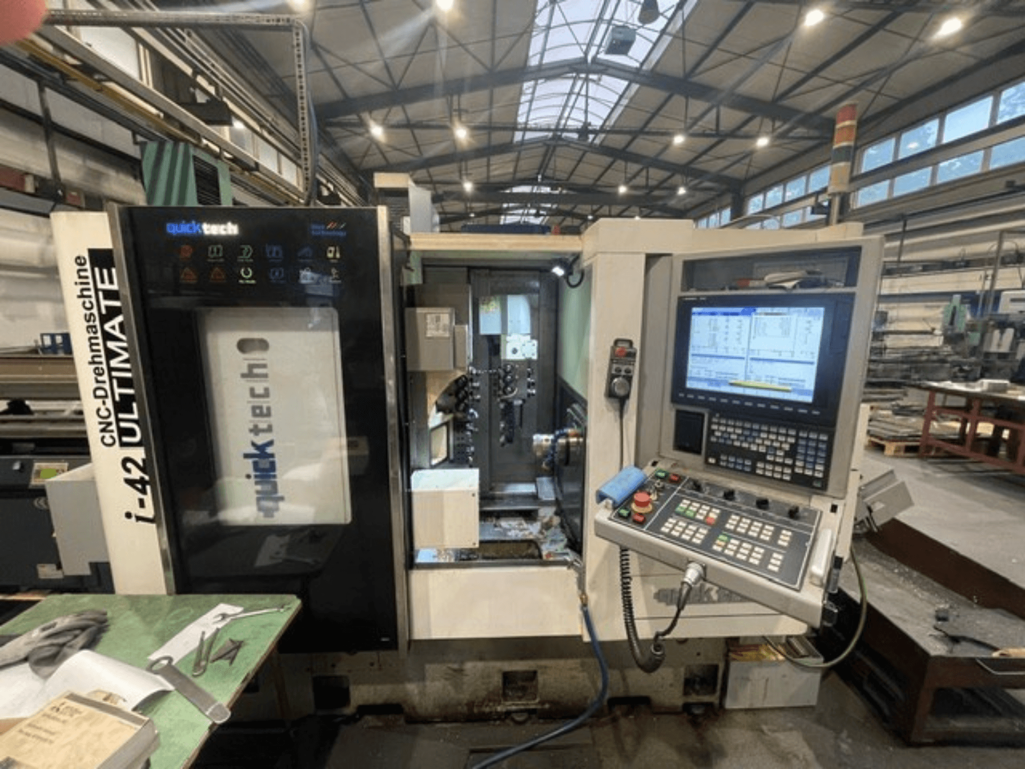 Quick-Tech I-42U Zwitserse draaimachine, vooraanzicht, met het bedieningspaneel en de CNC-interface in een werkplaats.
