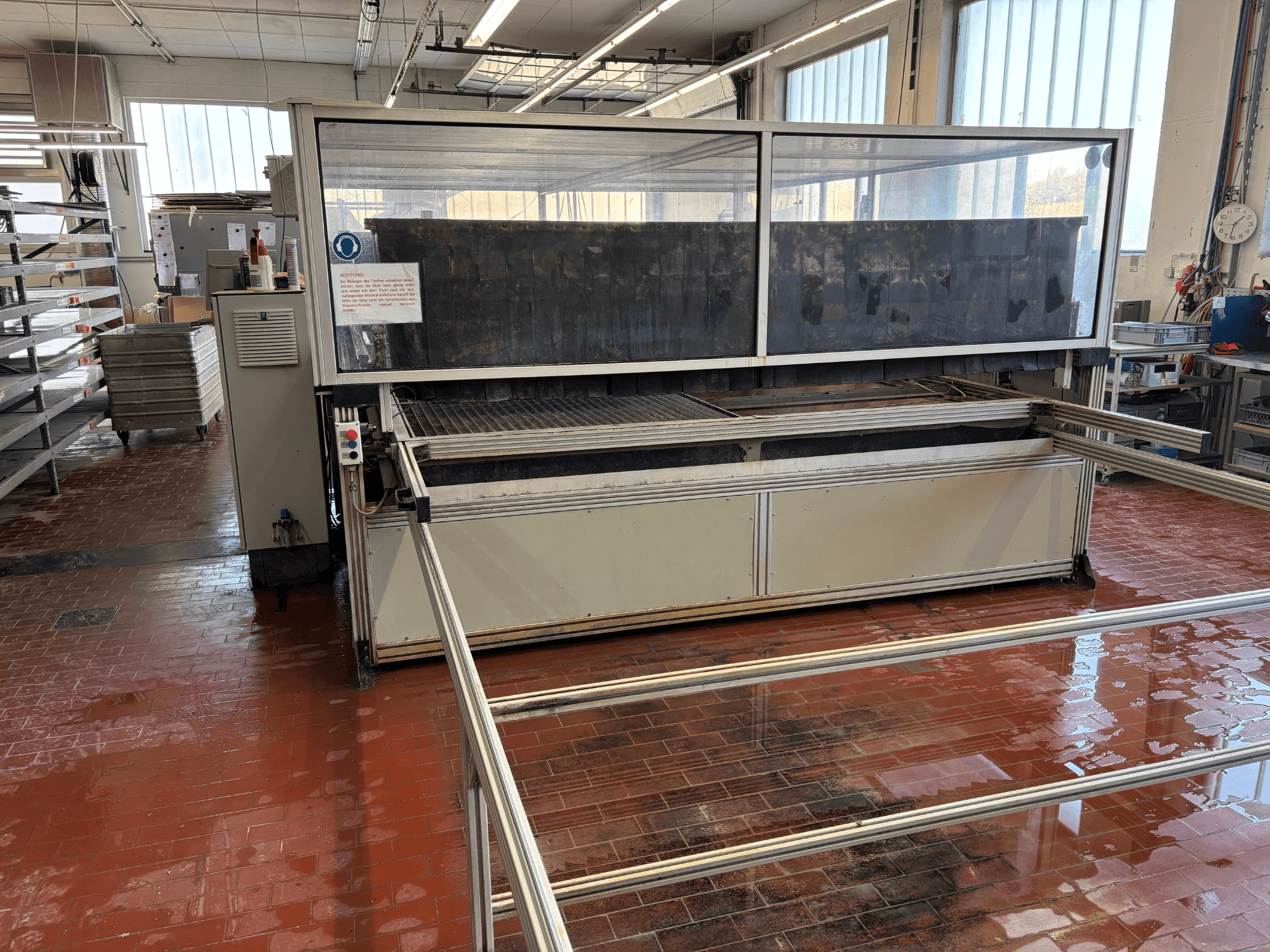 Waterstraalsnijmachine EXPERT SYSTEMTECHNIK cutExpert variojet in een werkplaats, vooraanzicht, met een grote doorzichtige afdekking.