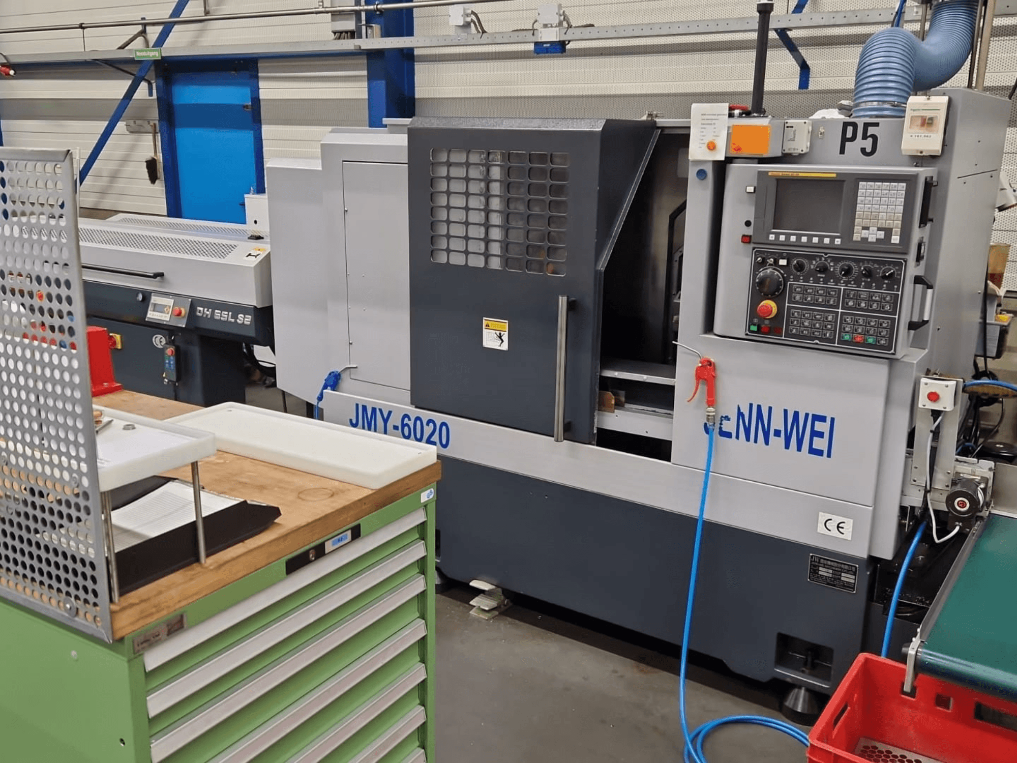 CNC draaibank, model JMY-6020 van cNN-WEI, gezien vanaf de voorkant. Voorzien van bedieningspaneel, noodstop en koelmiddelleiding.