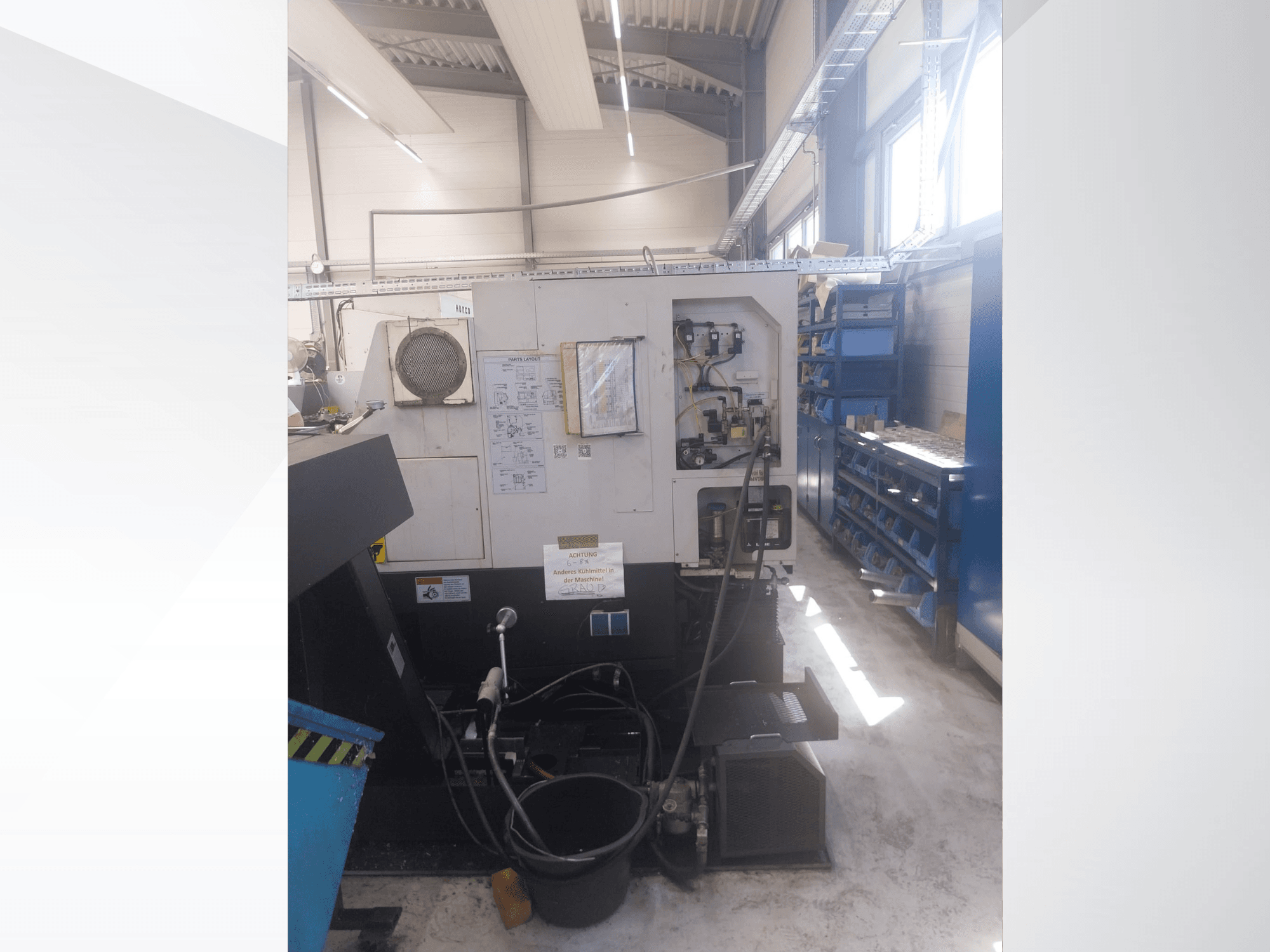 Mazak QUICK TURN NEXUS 200 MS, zijaanzicht met bedieningspaneel, slangen en gereedschapsruimte in een werkplaatsomgeving.