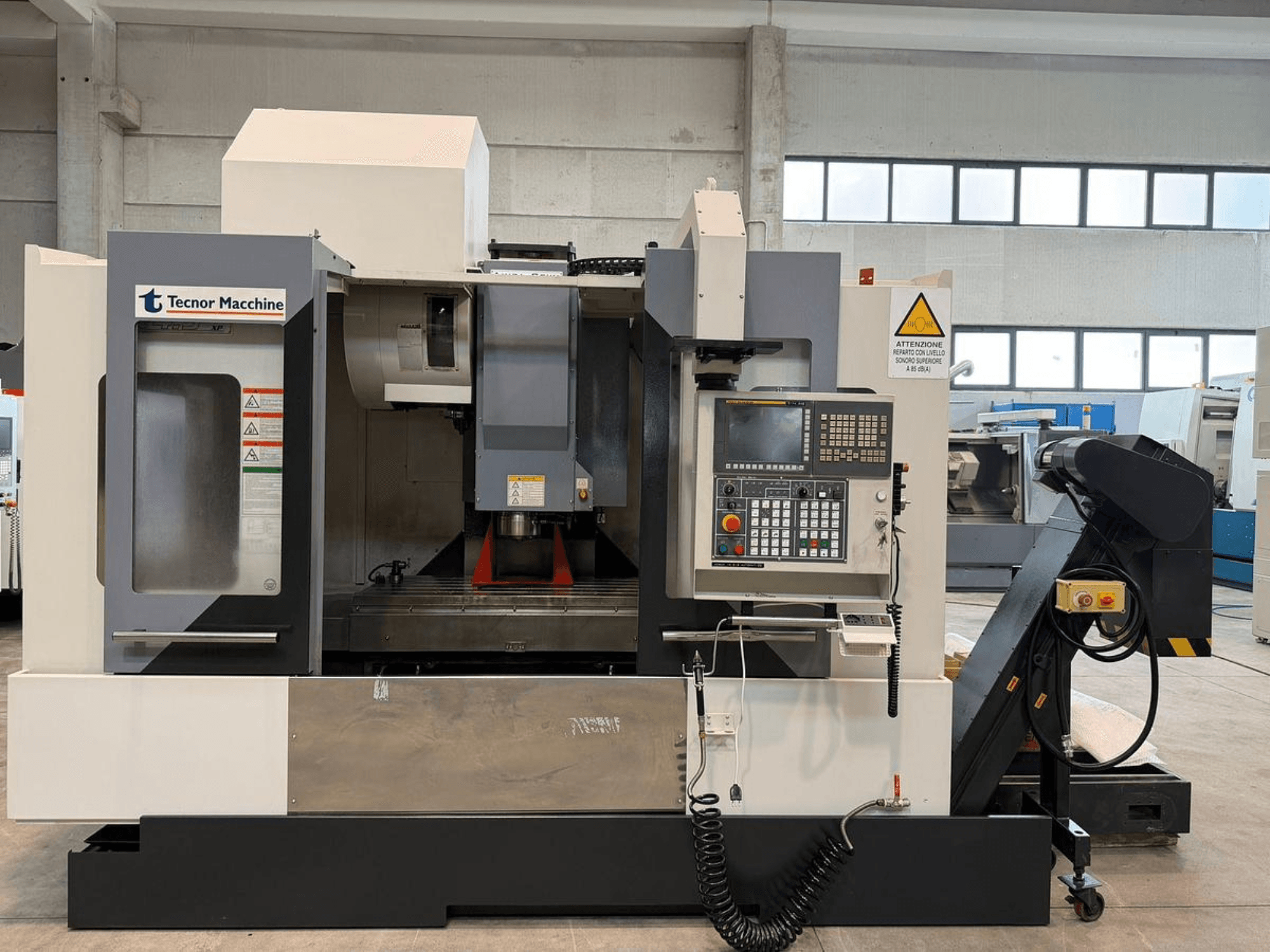Tecnor Machine CNC freesmachine, vooraanzicht, voorzien van bedieningspaneel met knoppen, waarschuwingslabels en gereedschaphouder.