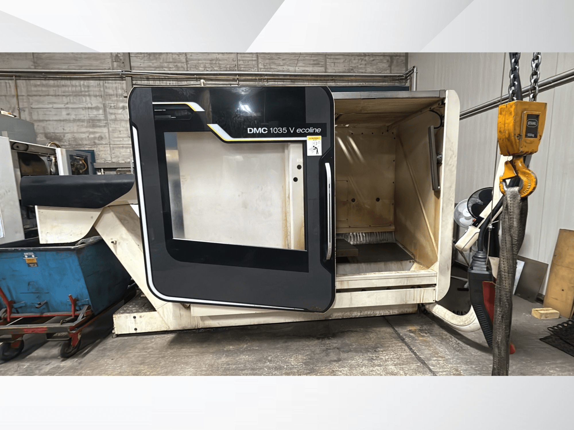 DMC 1035 V ecoline CNC machine, vooraanzicht, met open deur die een leeg interieur en bedieningspaneel onthult.