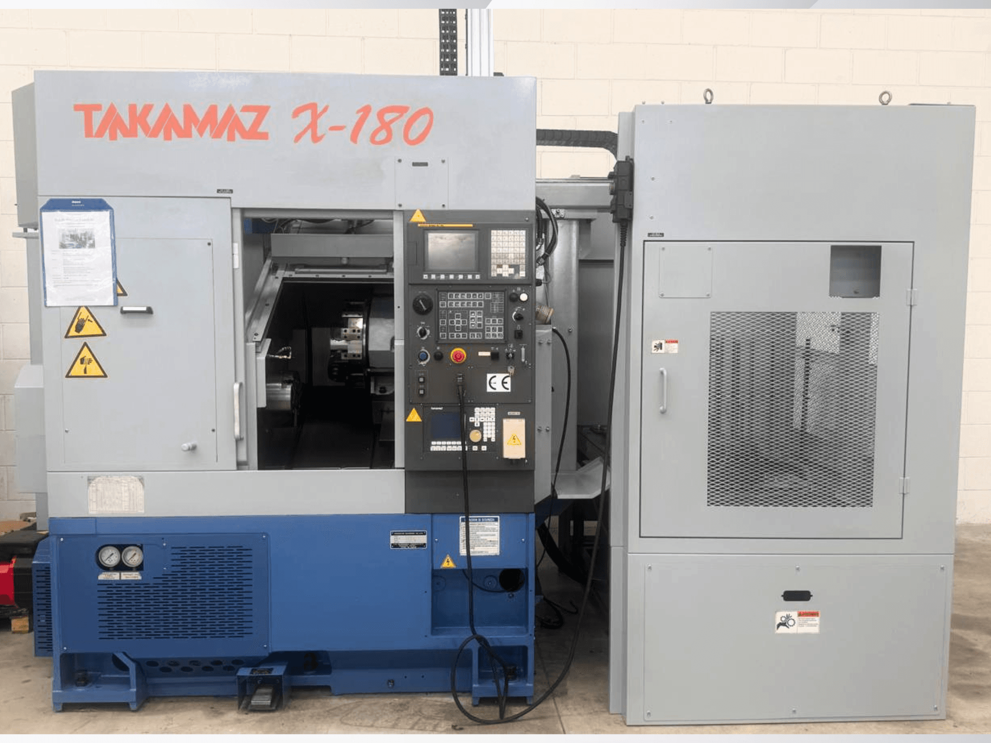 Horizontale draaibank Takamaz X-180, vooraanzicht met bedieningspaneel, veiligheidsstickers en de aangrenzende koeleenheid.