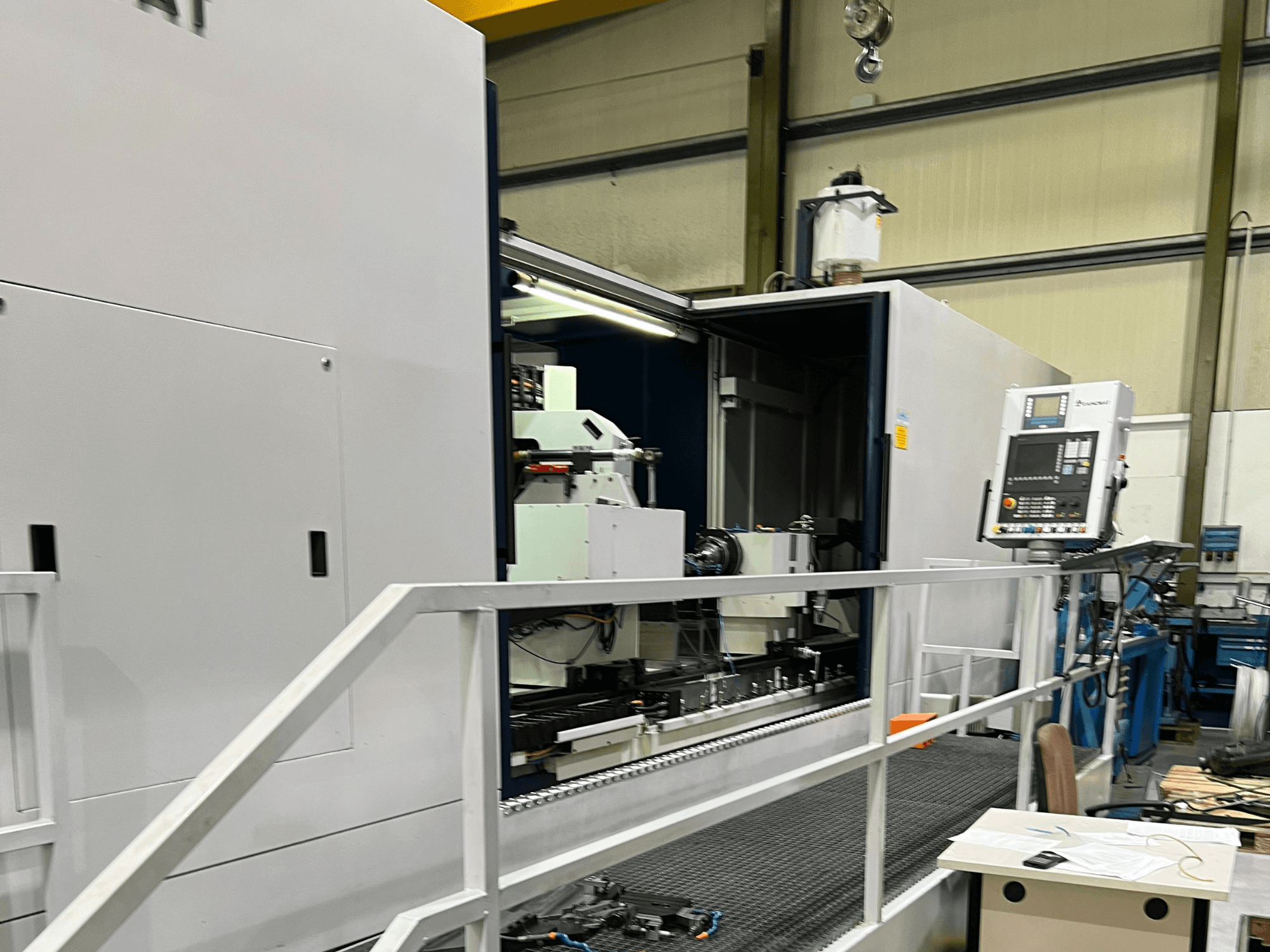 CNC-bewerkingscentrum met open zijaanzicht, waarop de bedieningselementen, gereedschaphouder en hoofdcomponent binnenin te zien zijn. Merkdetails niet zichtbaar.