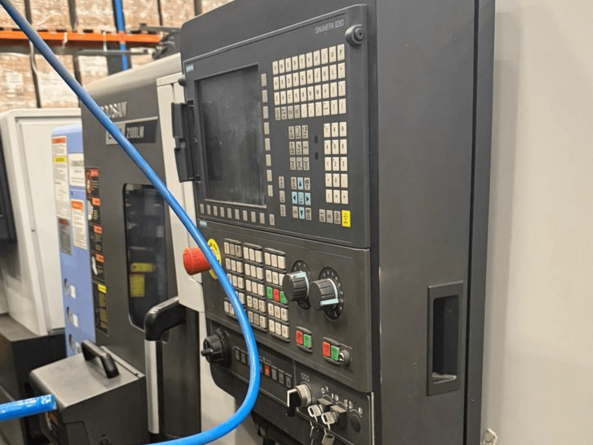 Bedieningspaneel van een bewerkingsgereedschap, vooraanzicht, met knoppen, draaiknoppen en een digitaal display voor nauwkeurige bediening.