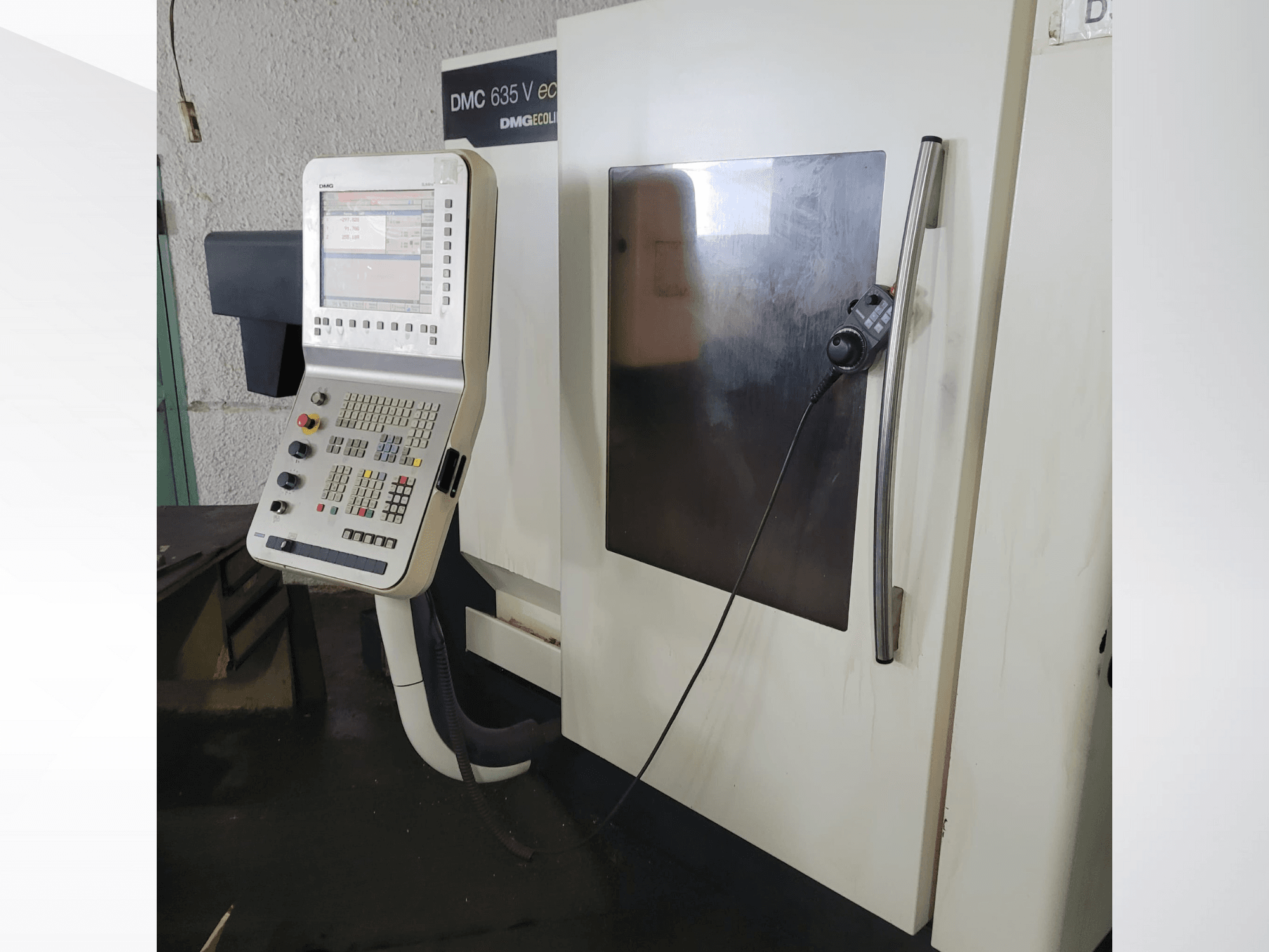DMG DMC 635 V eco CNC machine vooraanzicht met een bedieningspaneel met knoppen en een monitor die bewerkingen weergeeft.