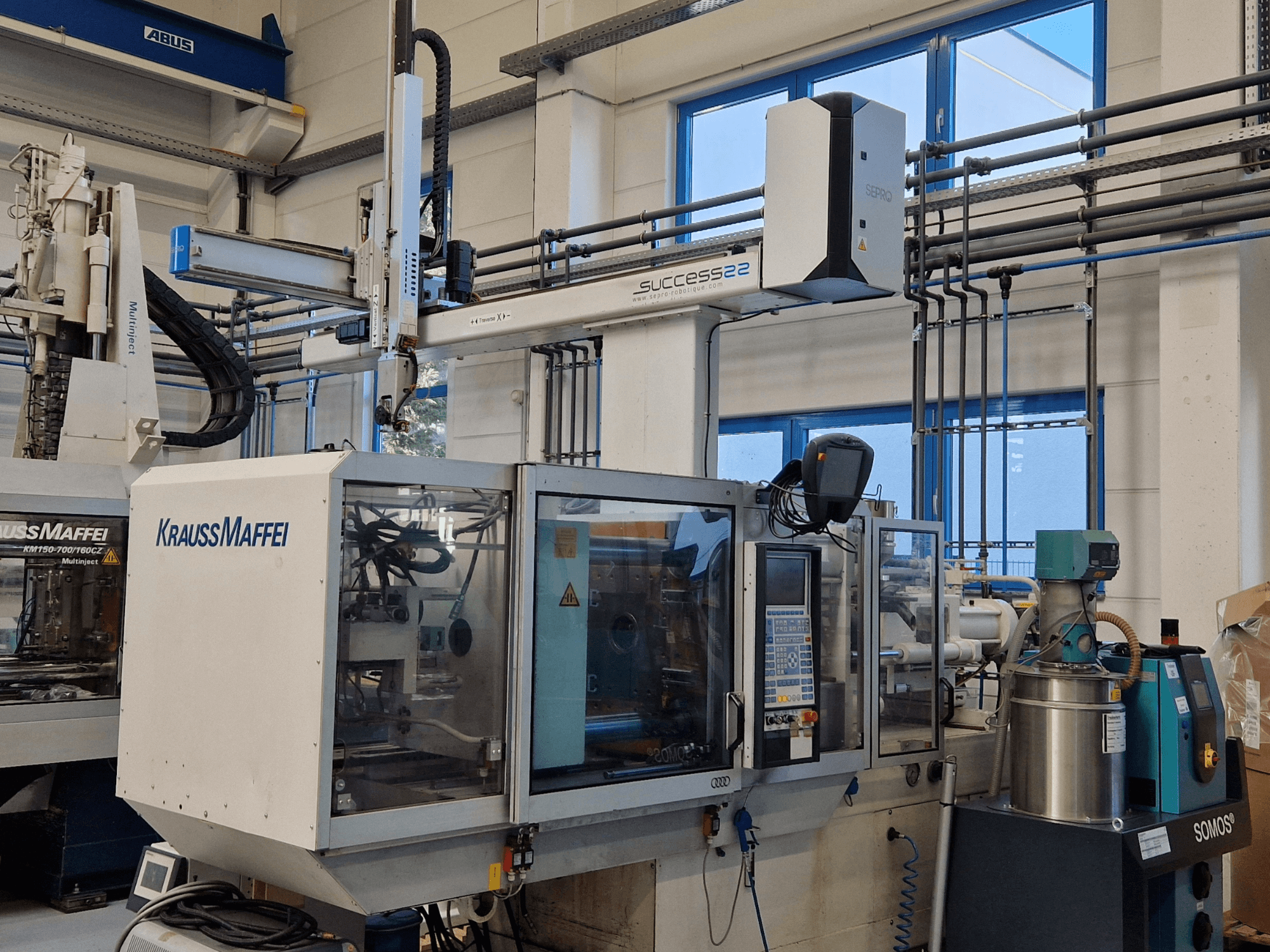 KraussMaffei Success 22 spuitgietmachine met bedieningspaneel, gezien vanaf de voorkant in een fabrieksomgeving.