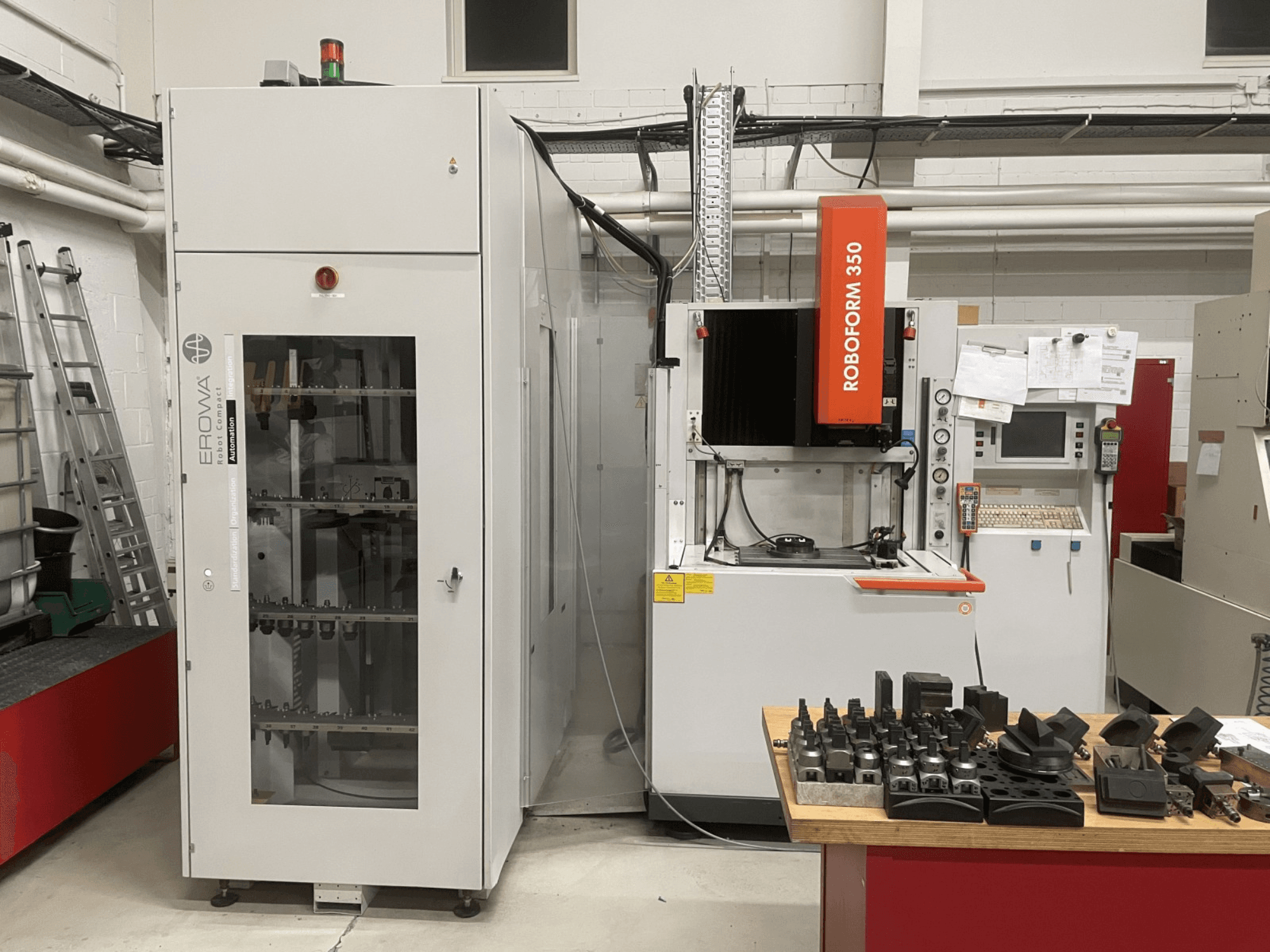Zinkvonkmachine CHARMILLES Roboform 350, vooraanzicht, met gereedschappen getoond op een tafel en aangrenzende apparatuur.
