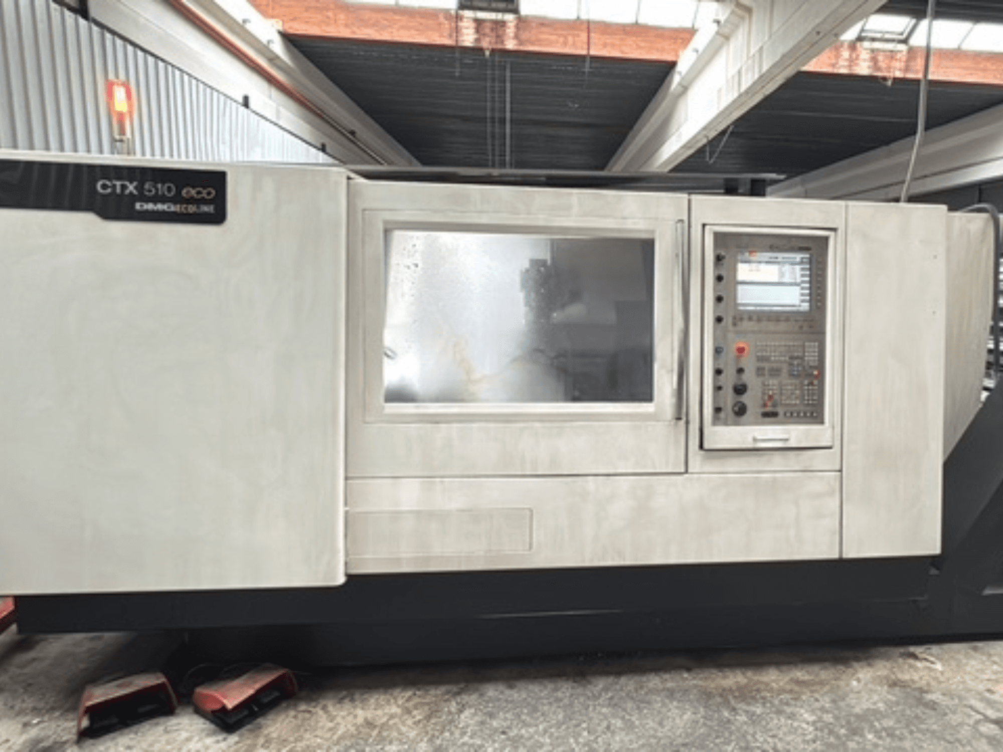Horizontale draaibank DMG CTX 510 ecoline, vooraanzicht, met het bedieningspaneel en het venster in de machinebehuizing.