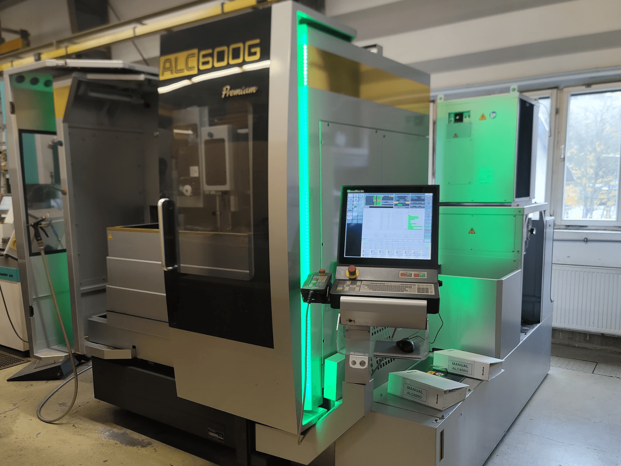 Sodick ALC600G Premium draadvonkmachine, vooraanzicht, met het bedieningspaneel en verlichte details aan de buitenkant.