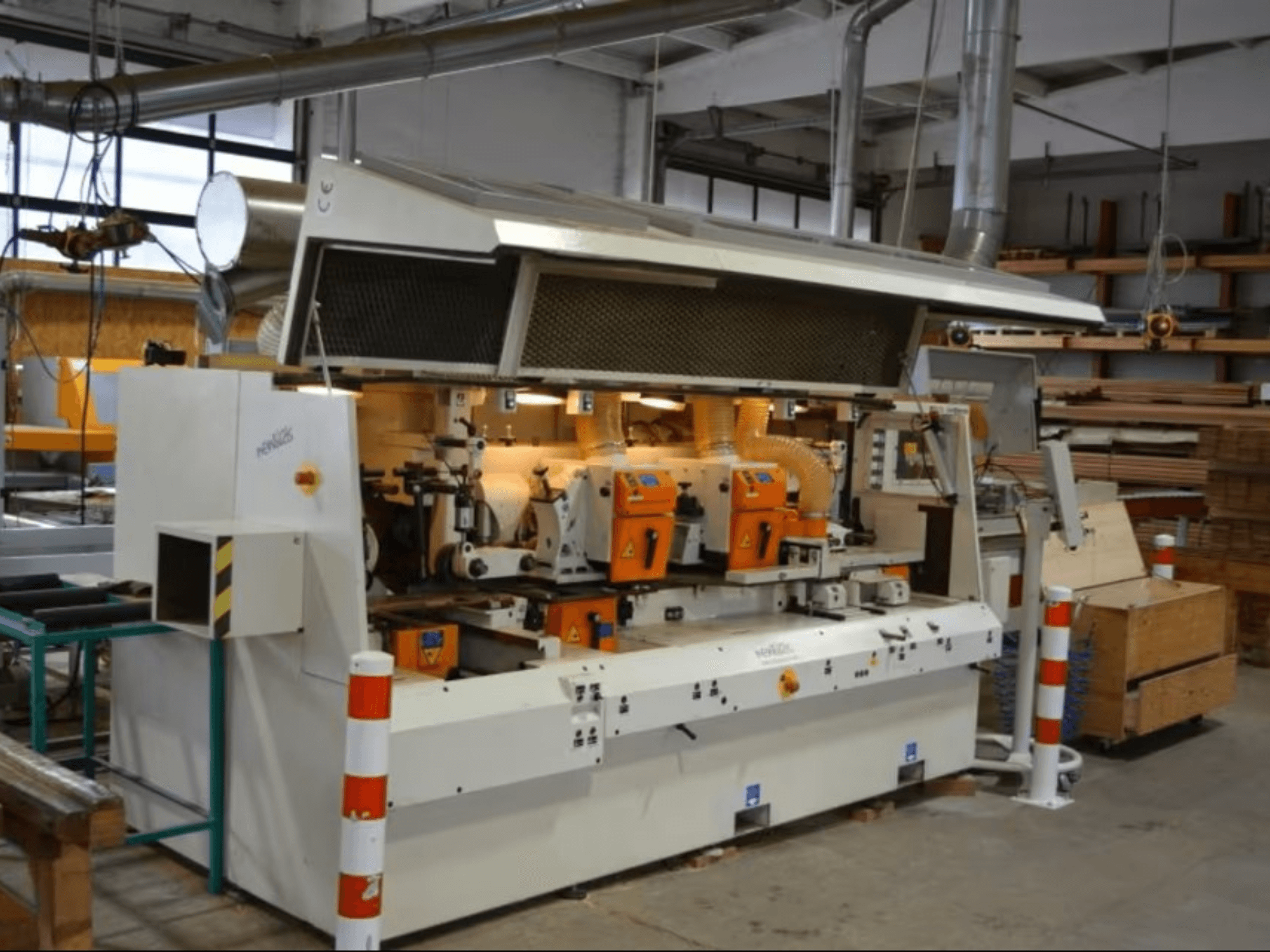 PENIGAS houtbewerkingsmachine, vooraanzicht, met dubbele oranje snijkoppen en stofafzuigsysteem in een werkplaats.