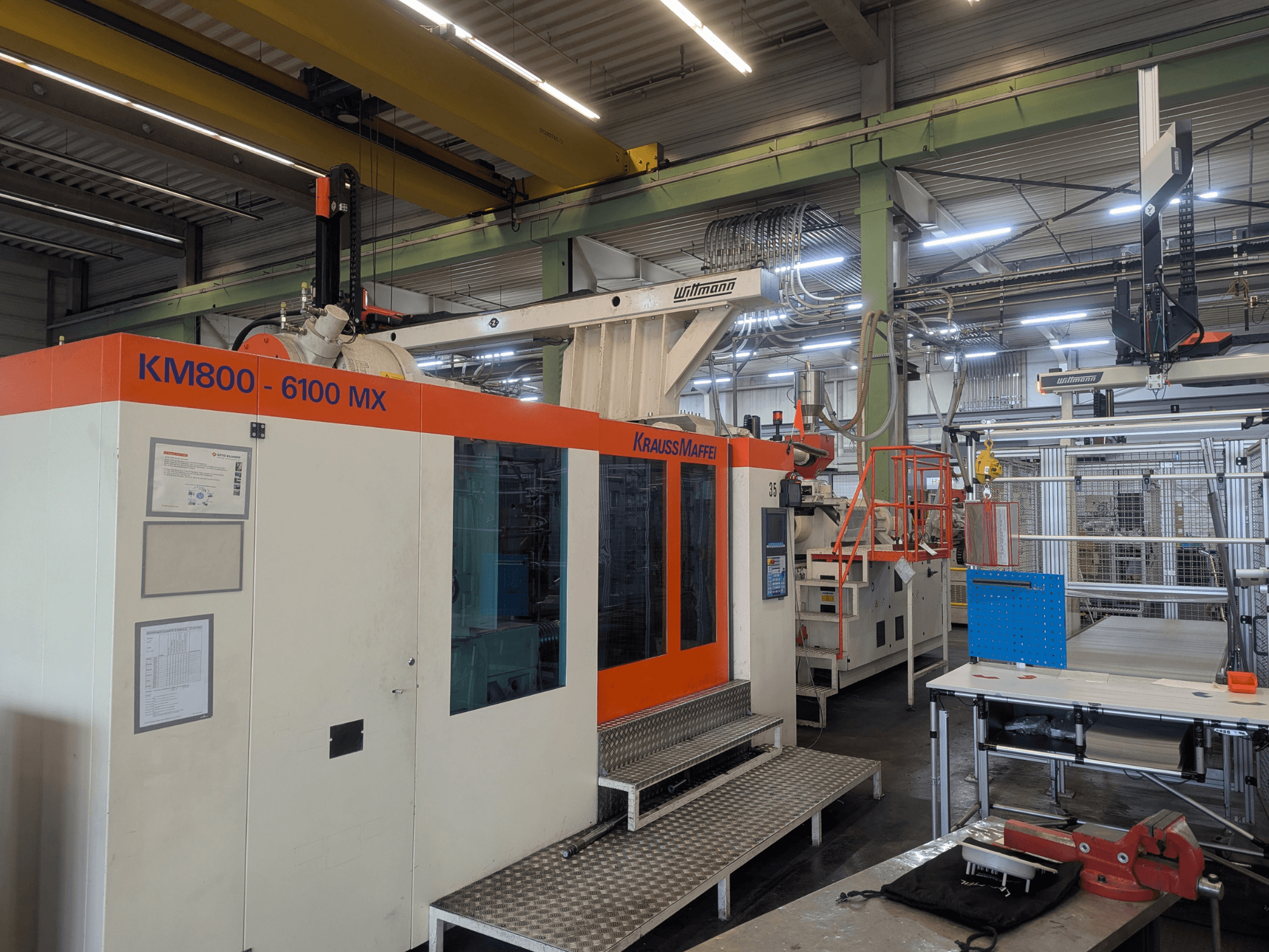 Krauss Maffei KM 800-6100MX hydraulische spuitgietmachine, vooraanzicht, met het bedieningspaneel en de industriële opstelling.