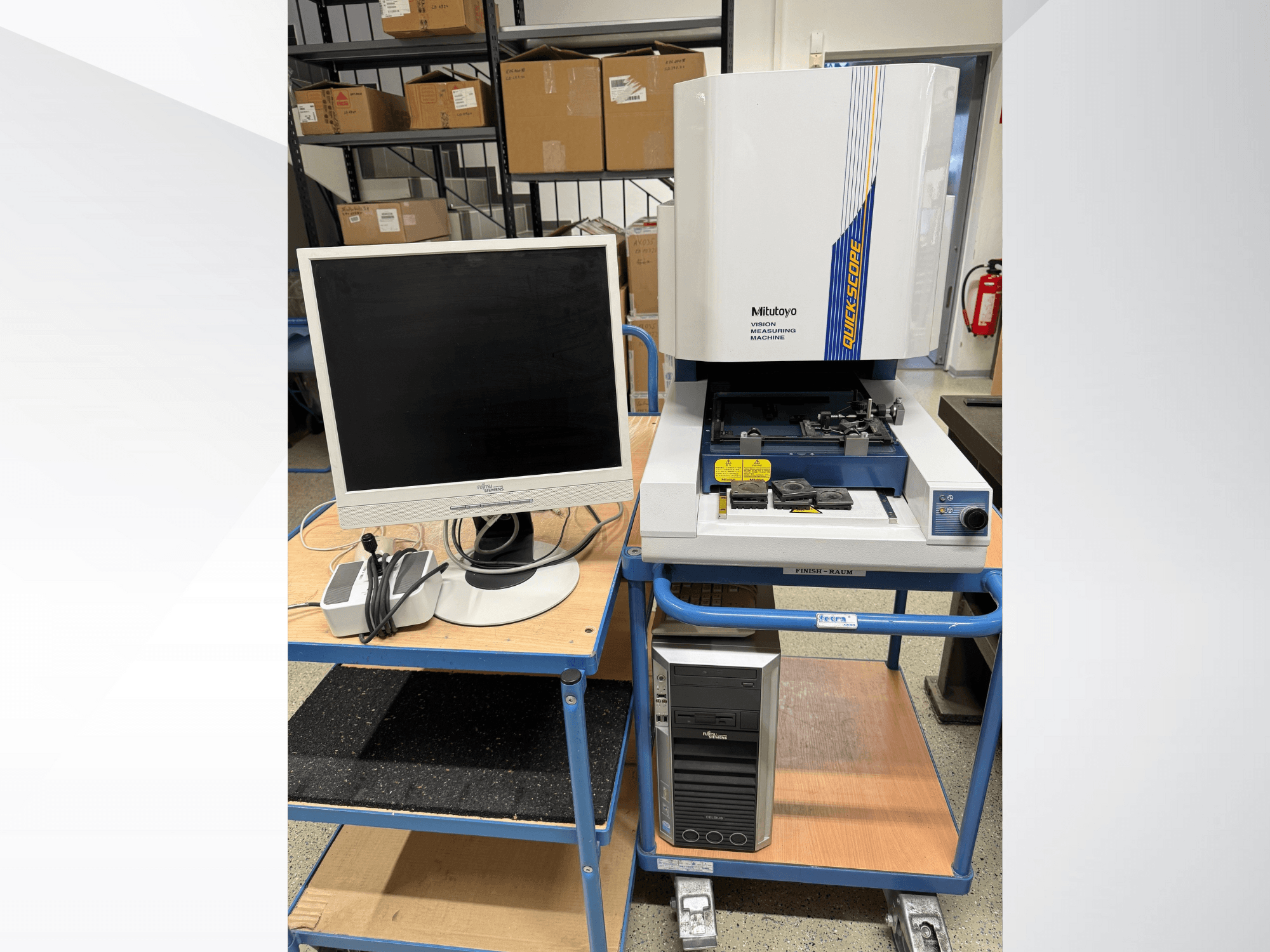 Mitutoyo Quick Scope vision meetmachine met monitor, PC en accessoires, vooraanzicht, op een blauwe trolley.