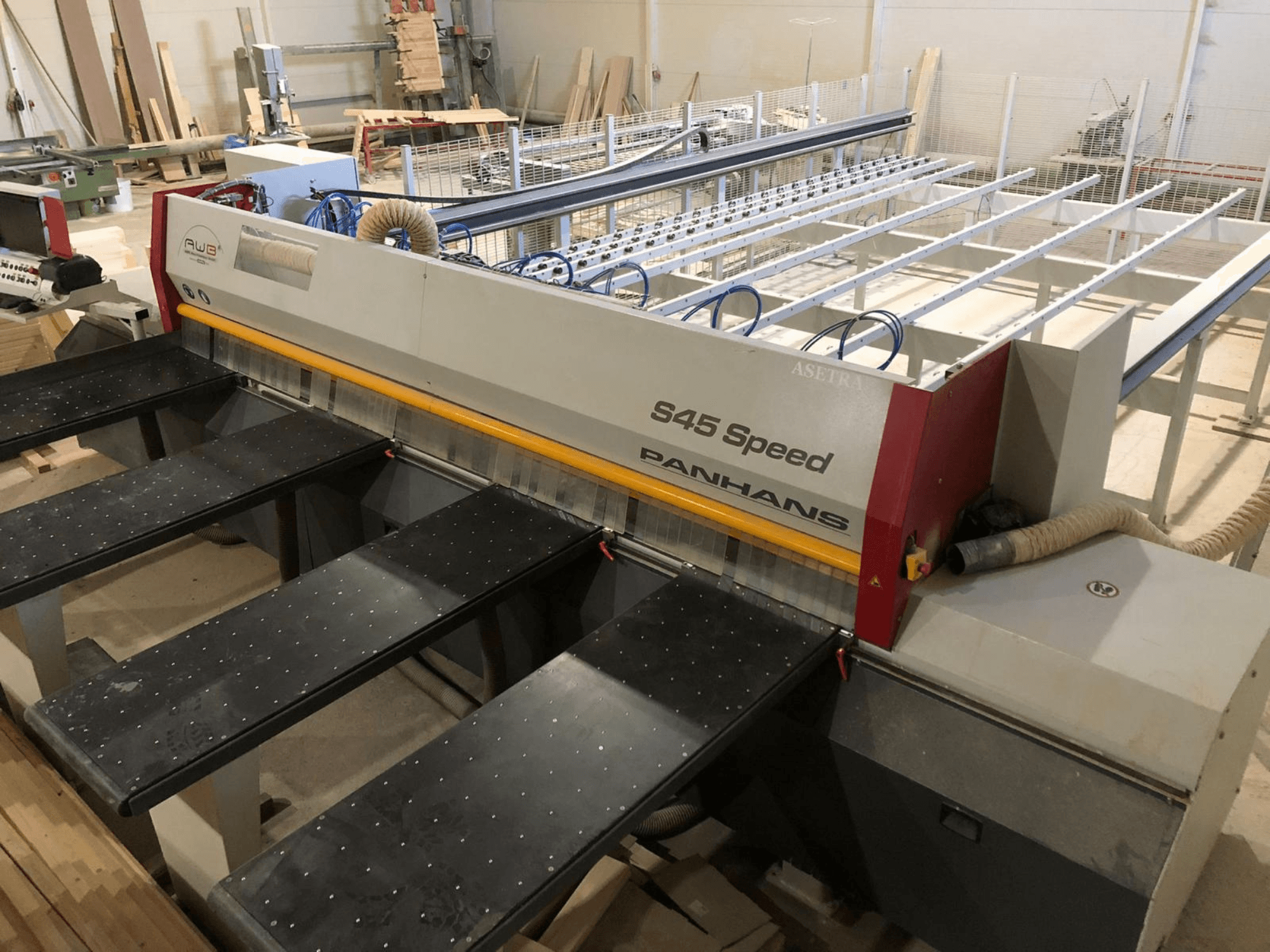 Zijaanzicht van een PANHANS S45 Speed paneelzaag, met een opstelling voor vijf tafels en een zichtbaar bedieningspaneel met stofafzuiging.