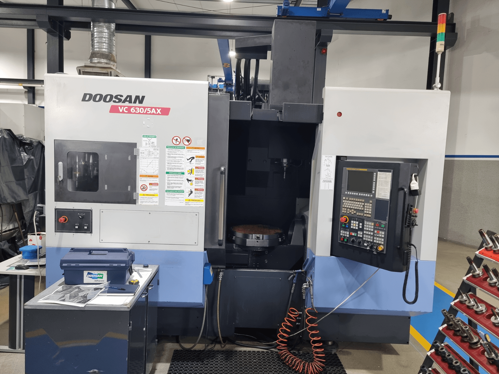 DOOSAN VC 630/5AX universeel bewerkingscentrum, vooraanzicht met het bedieningspaneel, het bewerkingsgebied en de veiligheidsvoorzieningen.