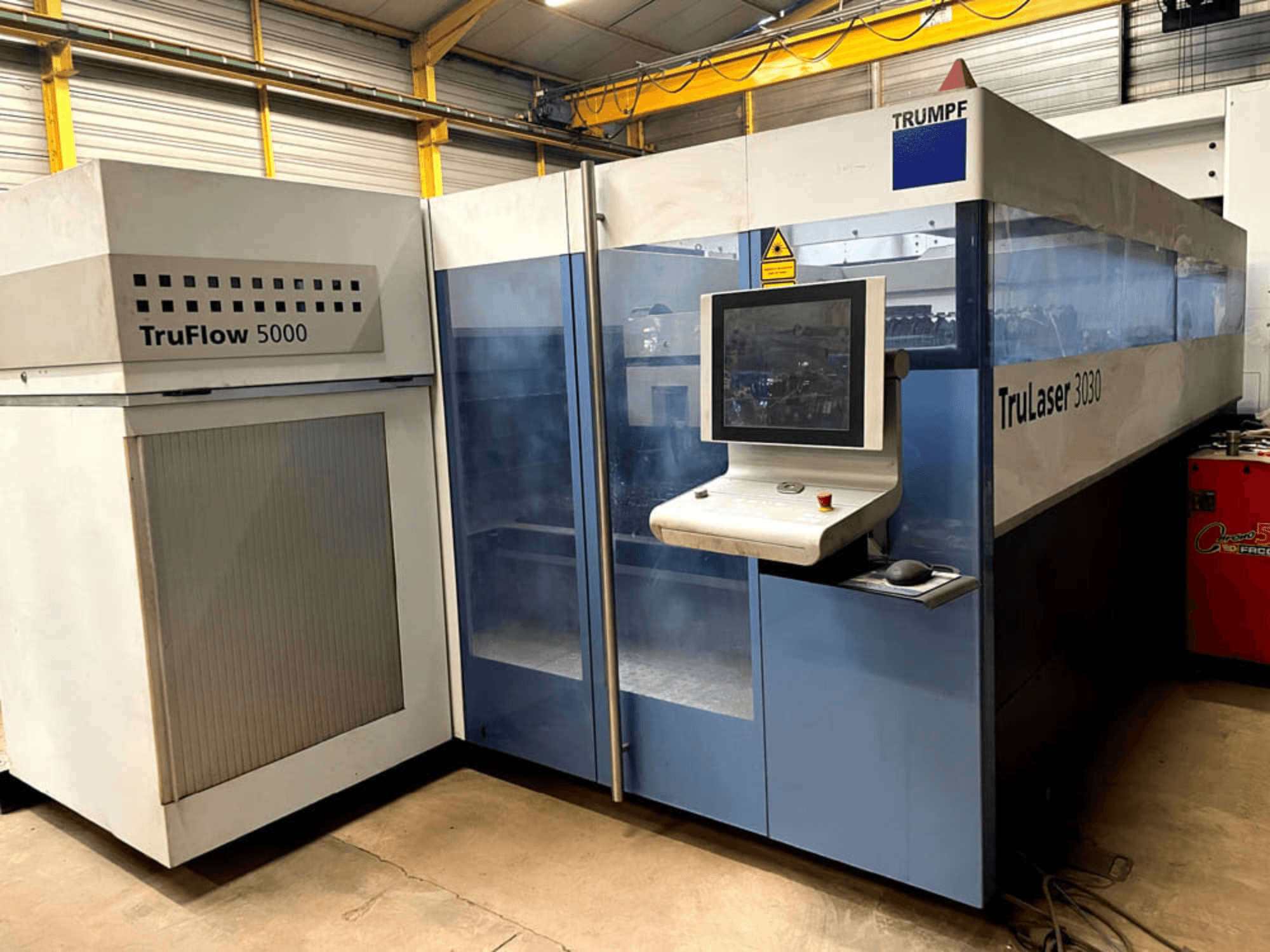 TRUMPF TruLaser 3030 CO₂-lasersnijmachine in vooraanzicht, met een bedieningspaneel en een aangrenzende TruFlow 5000-unit.