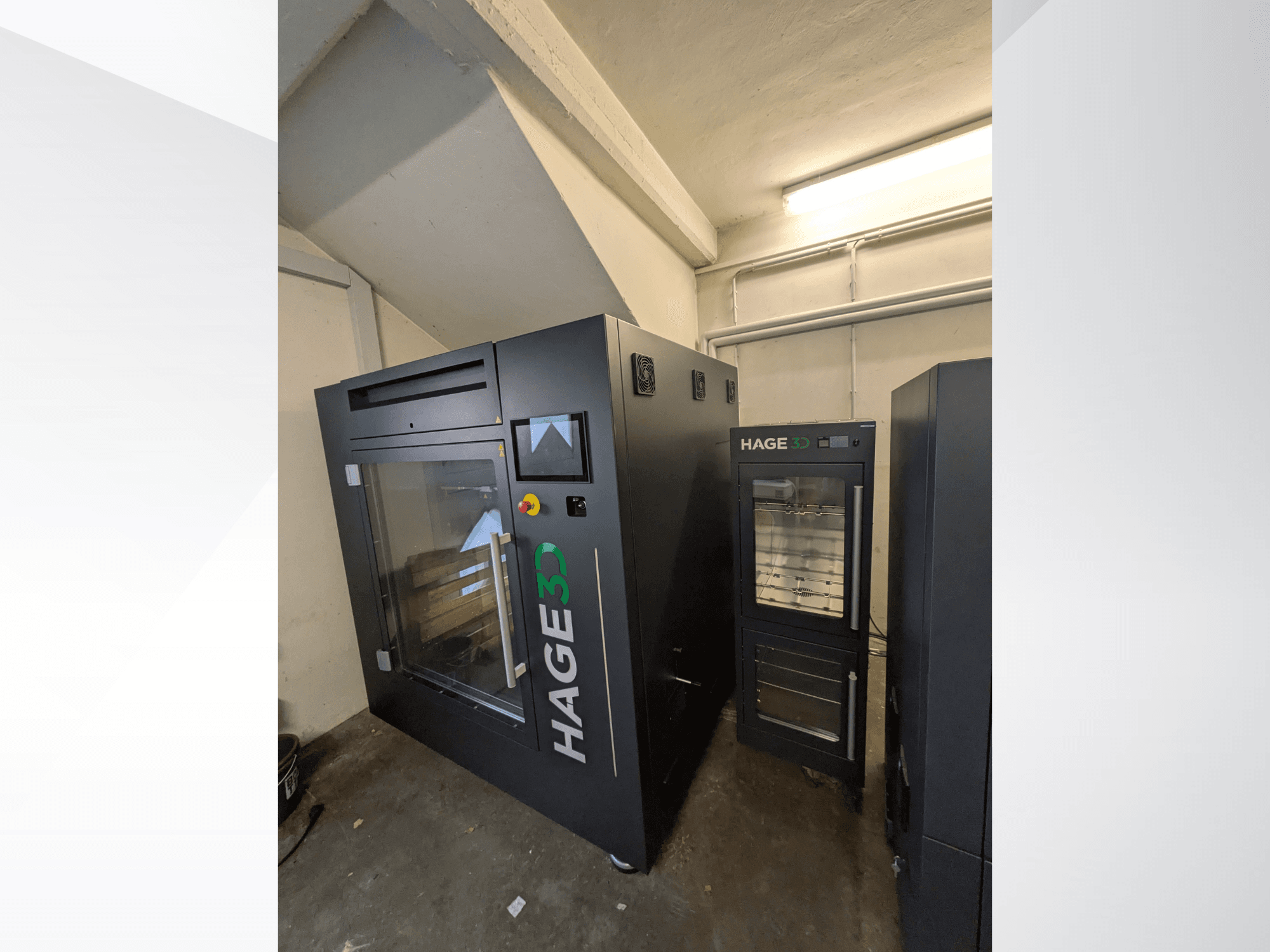 De HAGE 3D Precision One kunststof 3D-printer, gezien vanuit een hoek, met een transparante deur en bedieningspaneel, en opbergruimte ernaast.