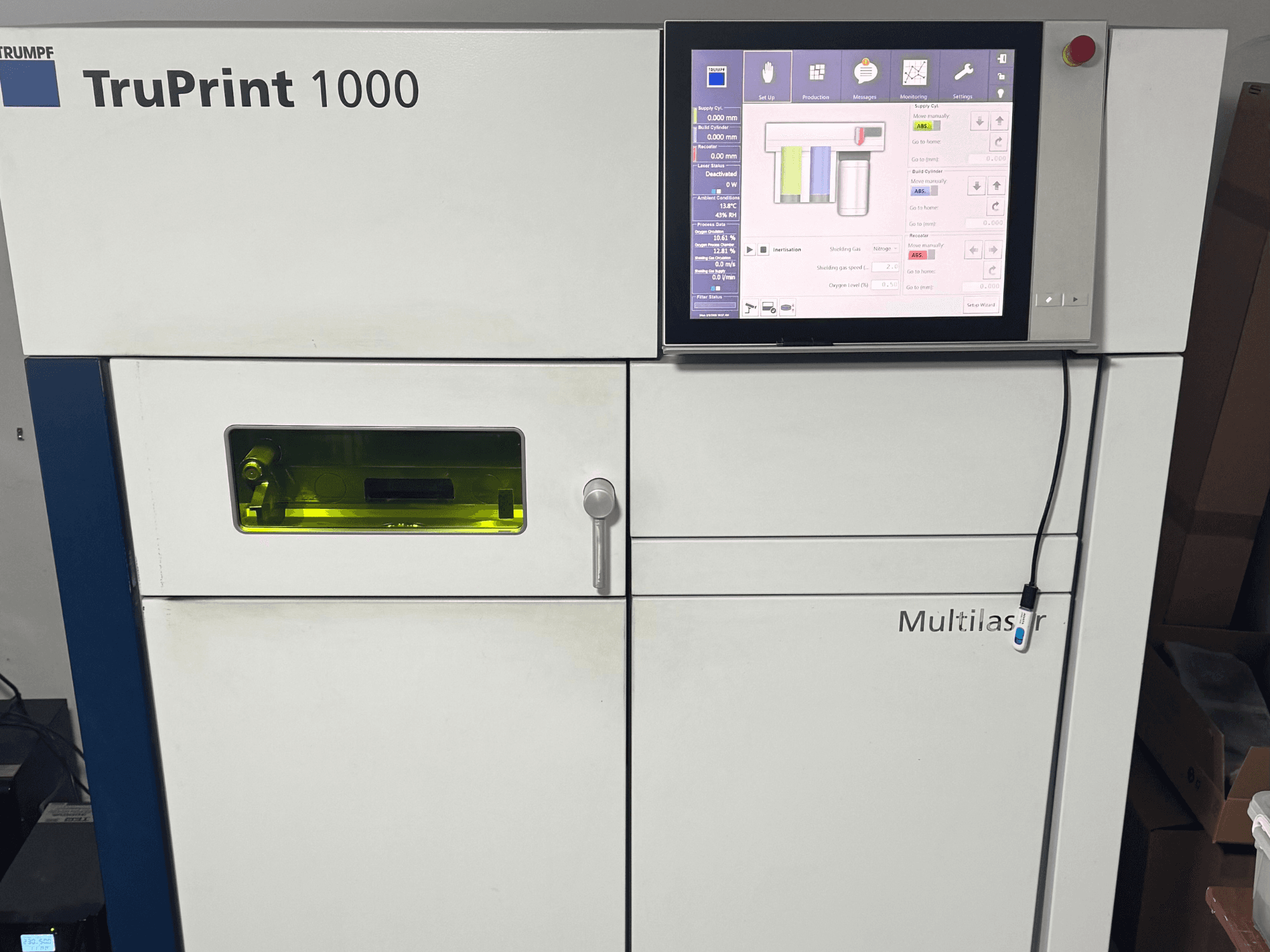 TruPrint 1000 van Trumpf, vooraanzicht, met een digitaal bedieningspaneel en een transparant inspectievenster voor controle.