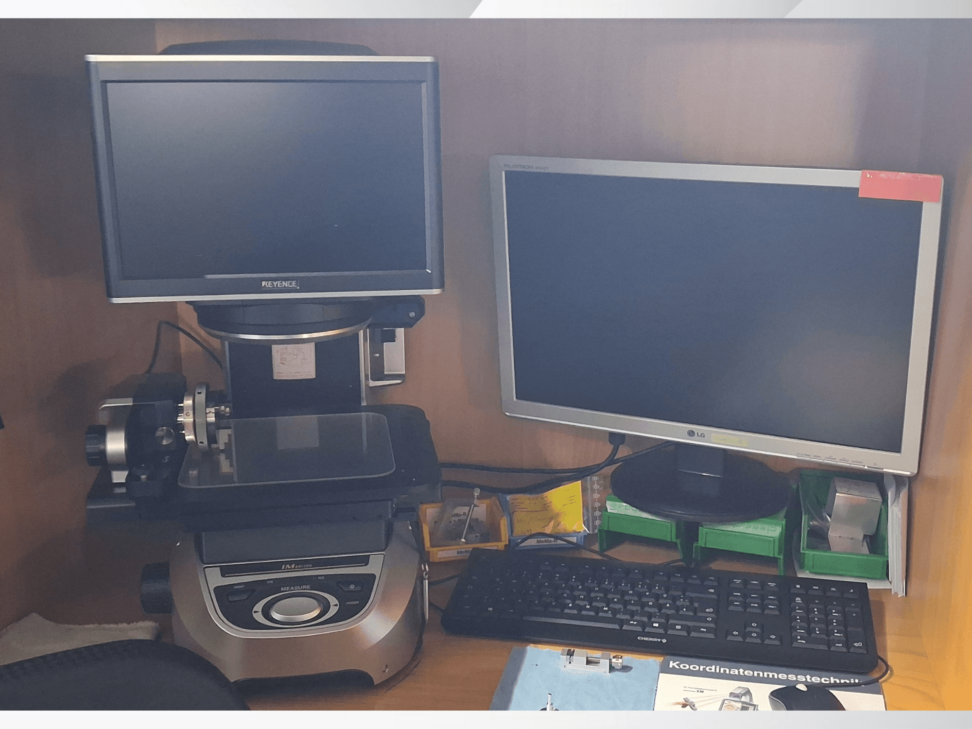 Keyence meetsysteem met twee monitoren (een LG, een Keyence) en een toetsenbord, gezien vanaf de voorkant.
