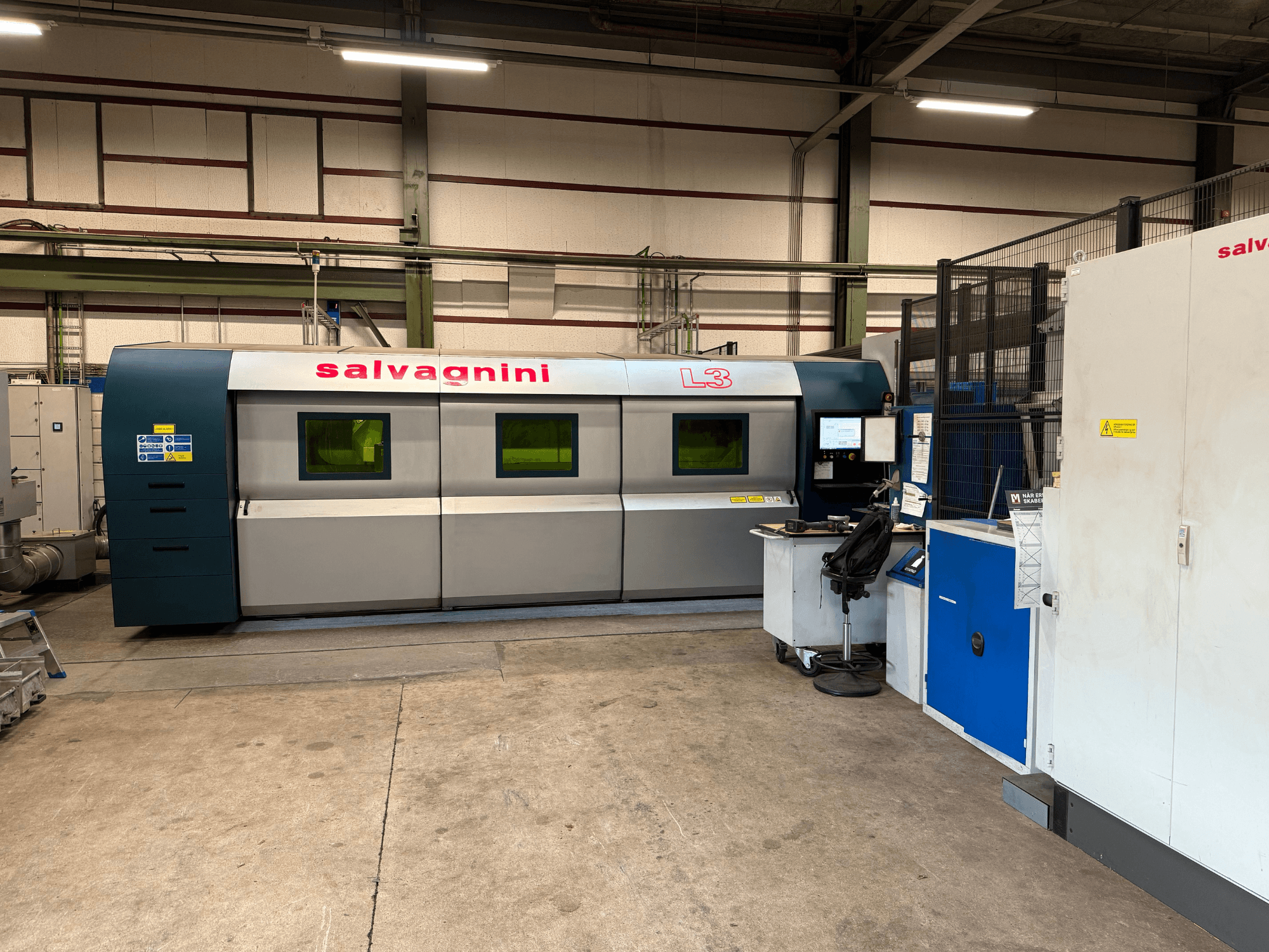 Salvagnini L3-4020 fiberlasersnijmachine in fabrieksinstelling, vooraanzicht, met bedieningspaneel en transportsysteem.