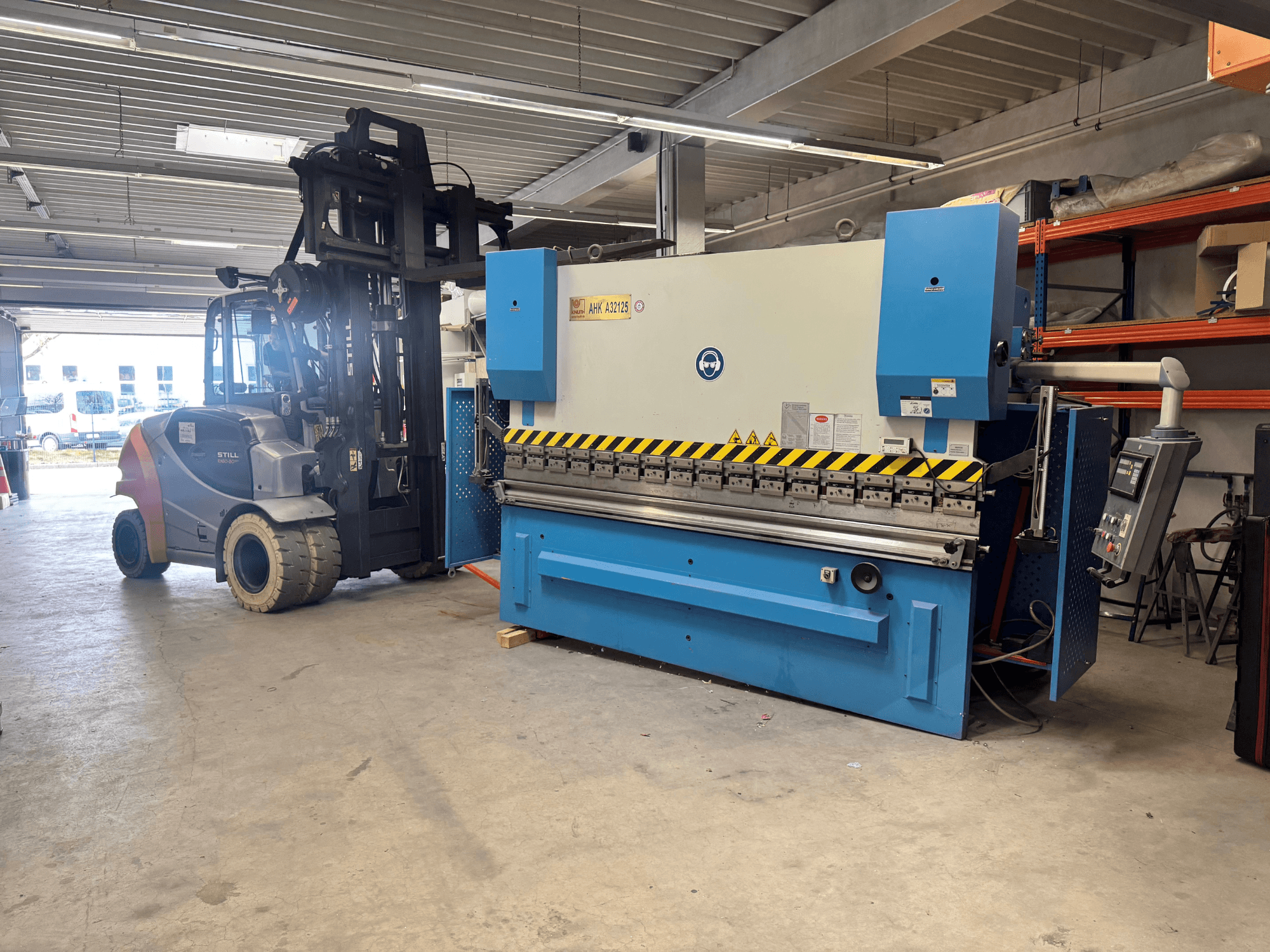 Hydraulische pers KNUTH AHK A 32125 in een werkplaats, zijaanzicht met bedieningspaneel en veiligheidsfuncties.