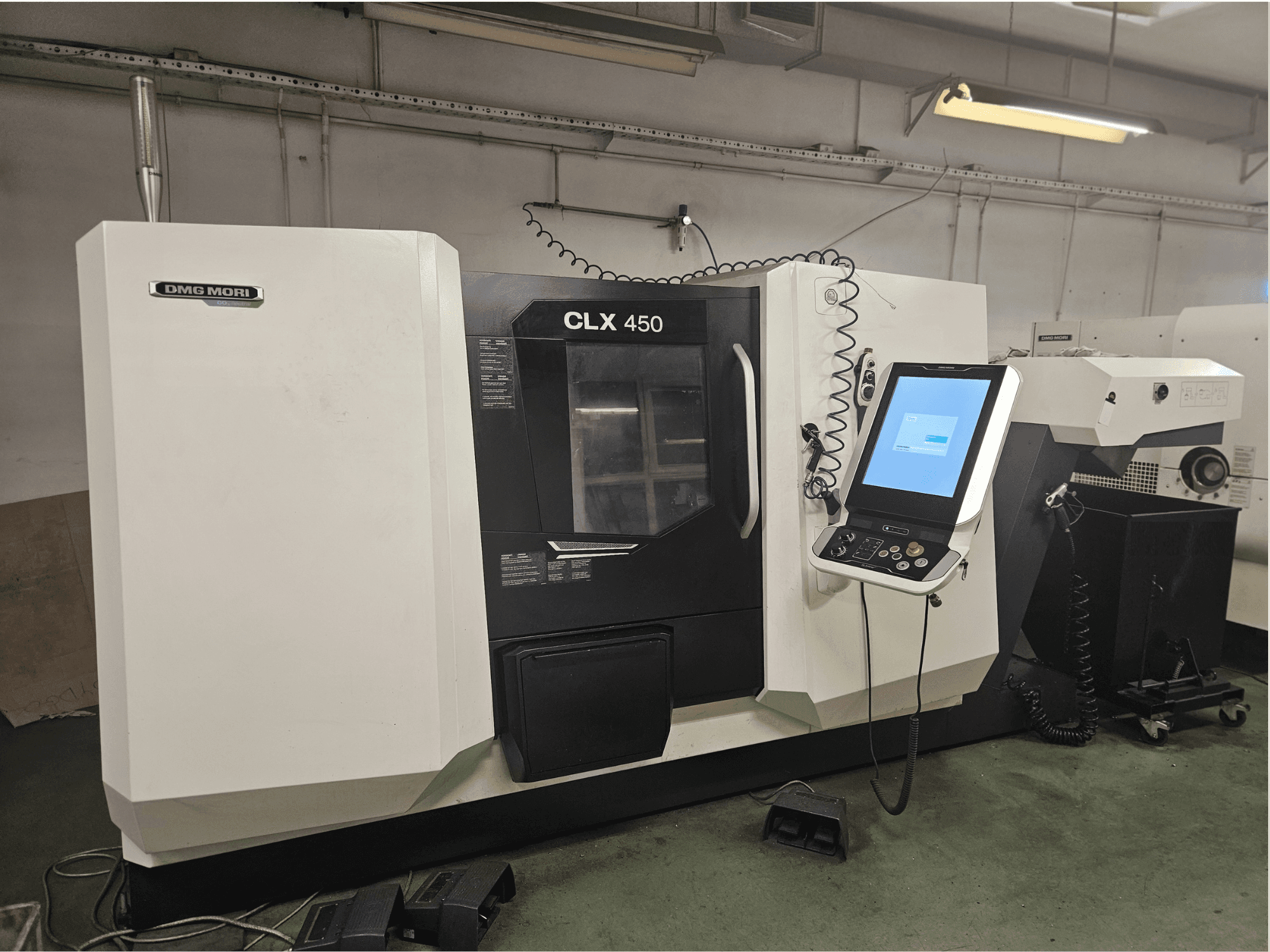 DMG MORI CLX 450 CNC machine in vooraanzicht, met bedieningspaneel en touchscreen display, opgesteld in een werkplaatsomgeving.