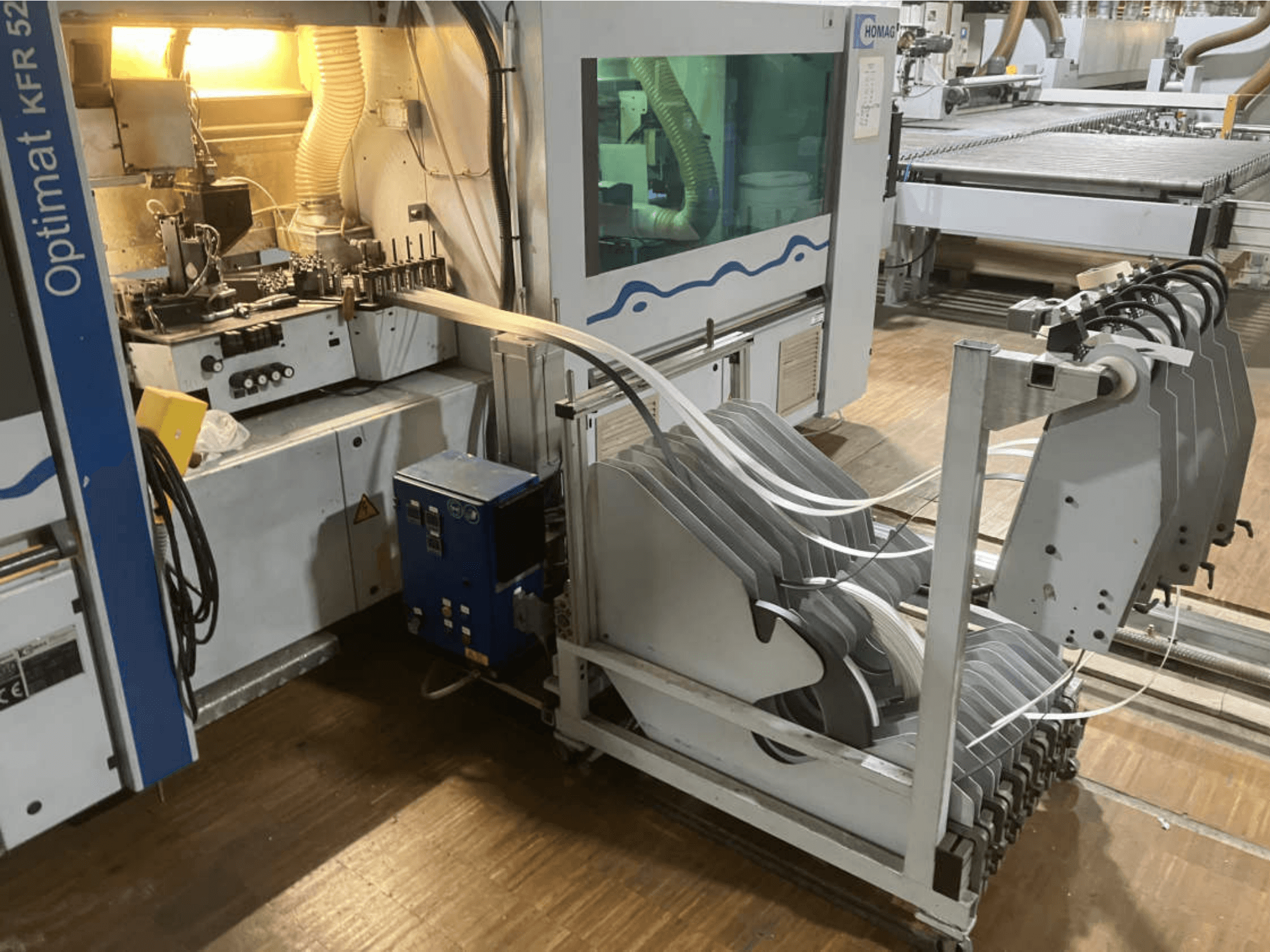 Dubbelzijdige kantenlijmmachine HOMAG Optimat KFR 526/10/A3/35, gezien vanaf de zijkant, met het bedieningspaneel en de kantenlijmrollen.