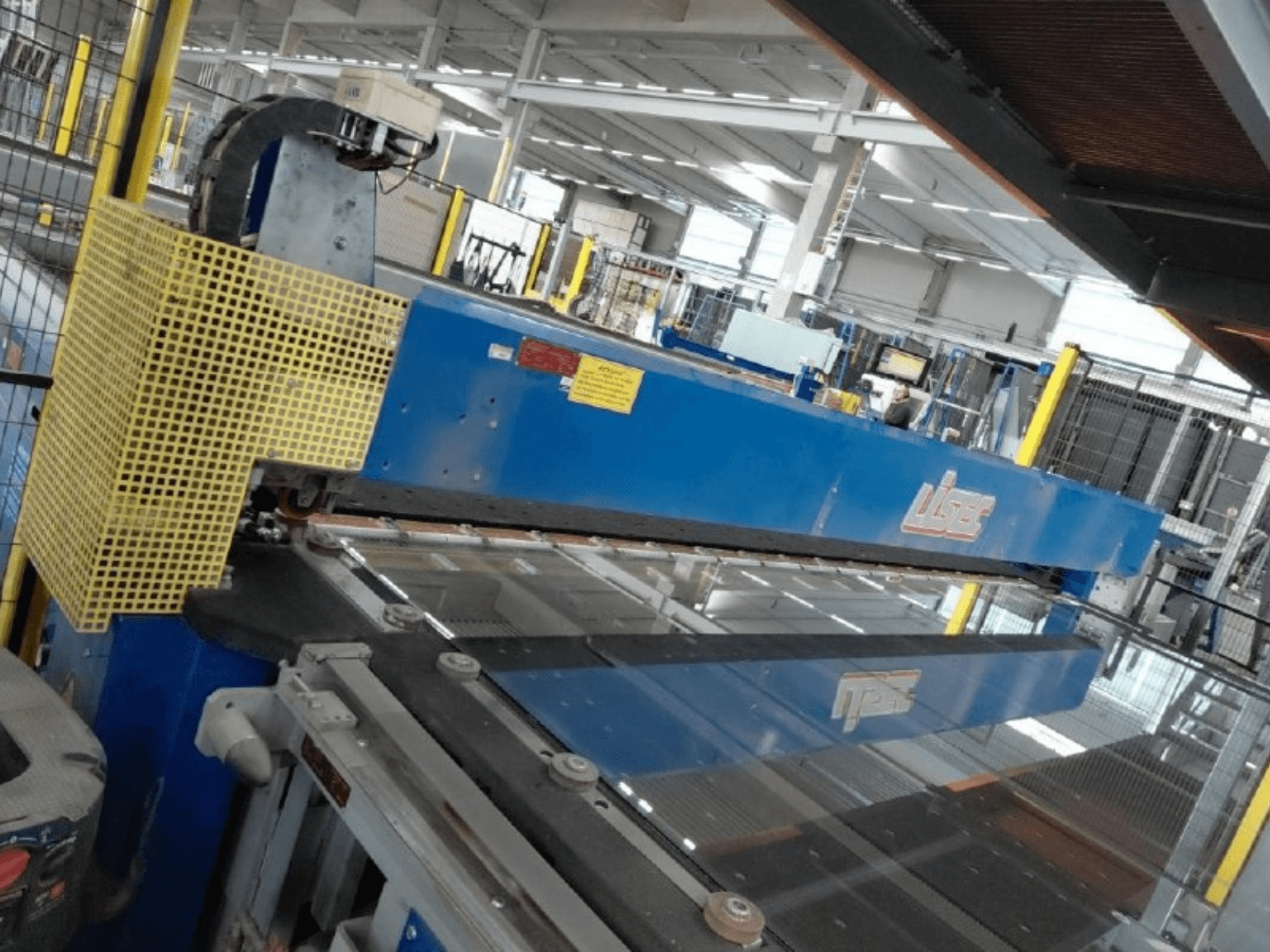 Vooraanzicht van de gecombineerde VSG- en floatglas-snijlijn van LISEC, met een blauw snijgereedschap en beschermgaas.