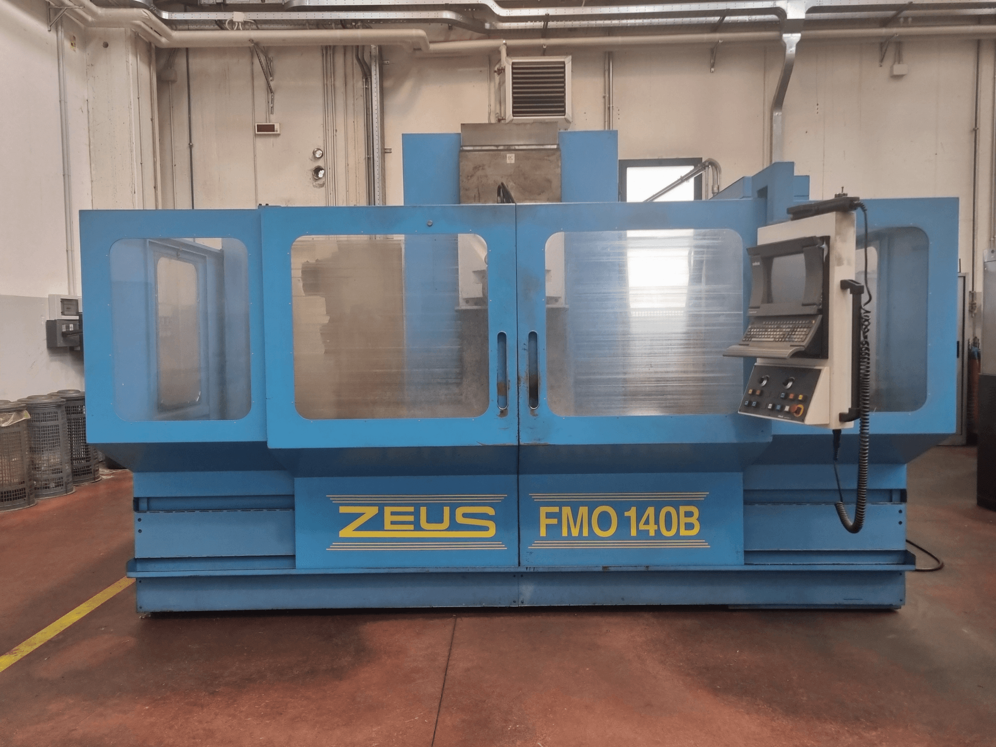 Zeus FMO 140B machine in blauw, vooraanzicht; voorzien van bedieningspaneel en grote transparante panelen voor zichtbaarheid.