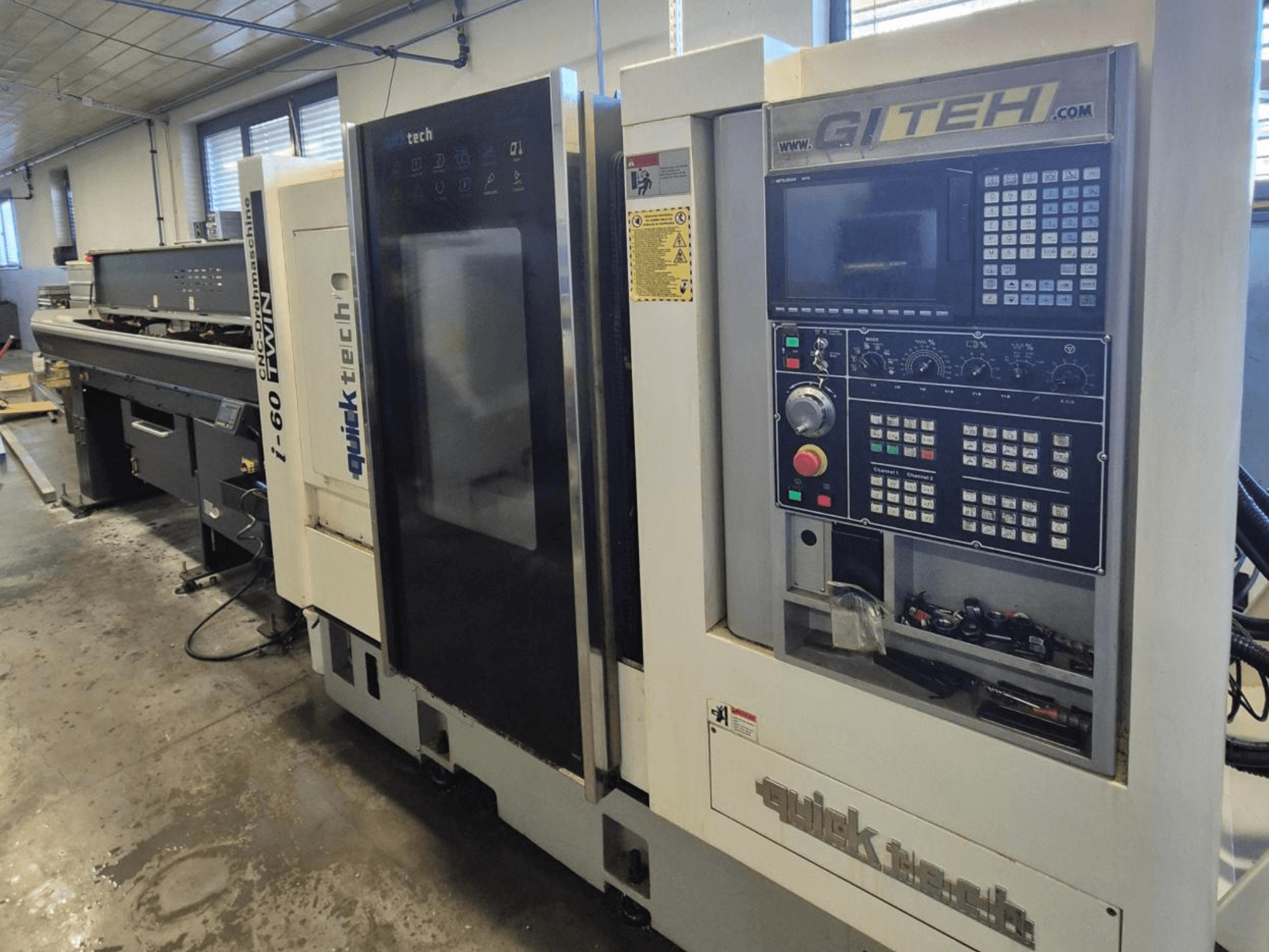 Quick Tech i-60 dubbele CNC machine, vooraanzicht, met GITEH bedieningspaneel en bedieningsknoppen, in een werkplaats.