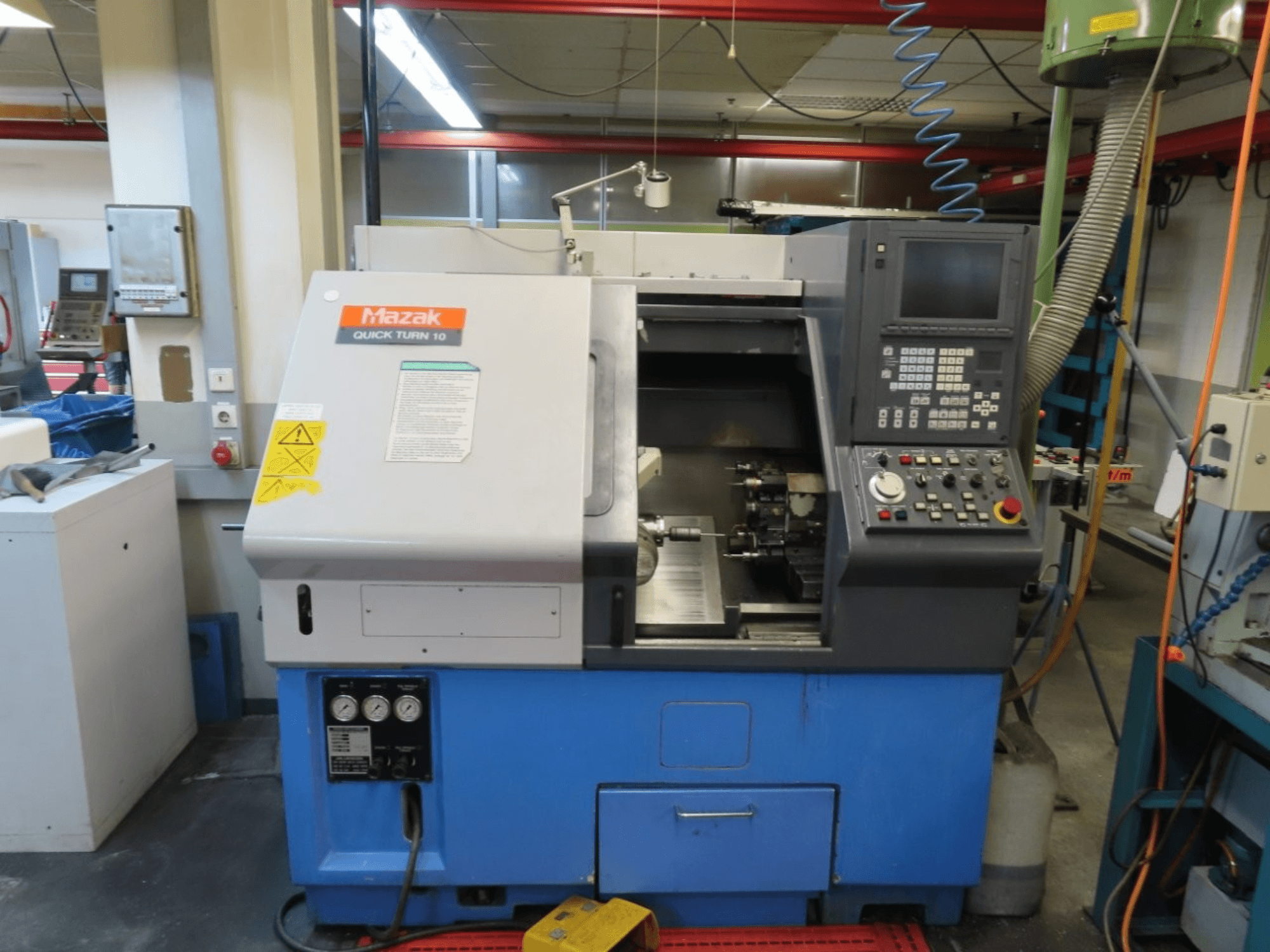 De horizontale draaimachine Mazak Quick Turn 10 in vooraanzicht, met bedieningspaneel, spil en koelsysteem.