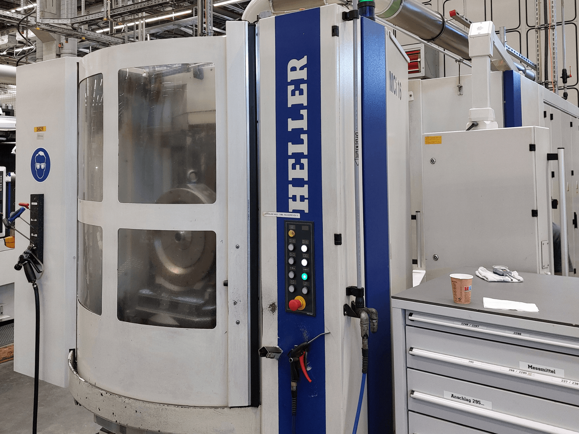 Het horizontale bewerkingscentrum Heller MCI 16 in zijaanzicht, met bedieningspaneel, doorzichtig venster en de omliggende werkruimte.