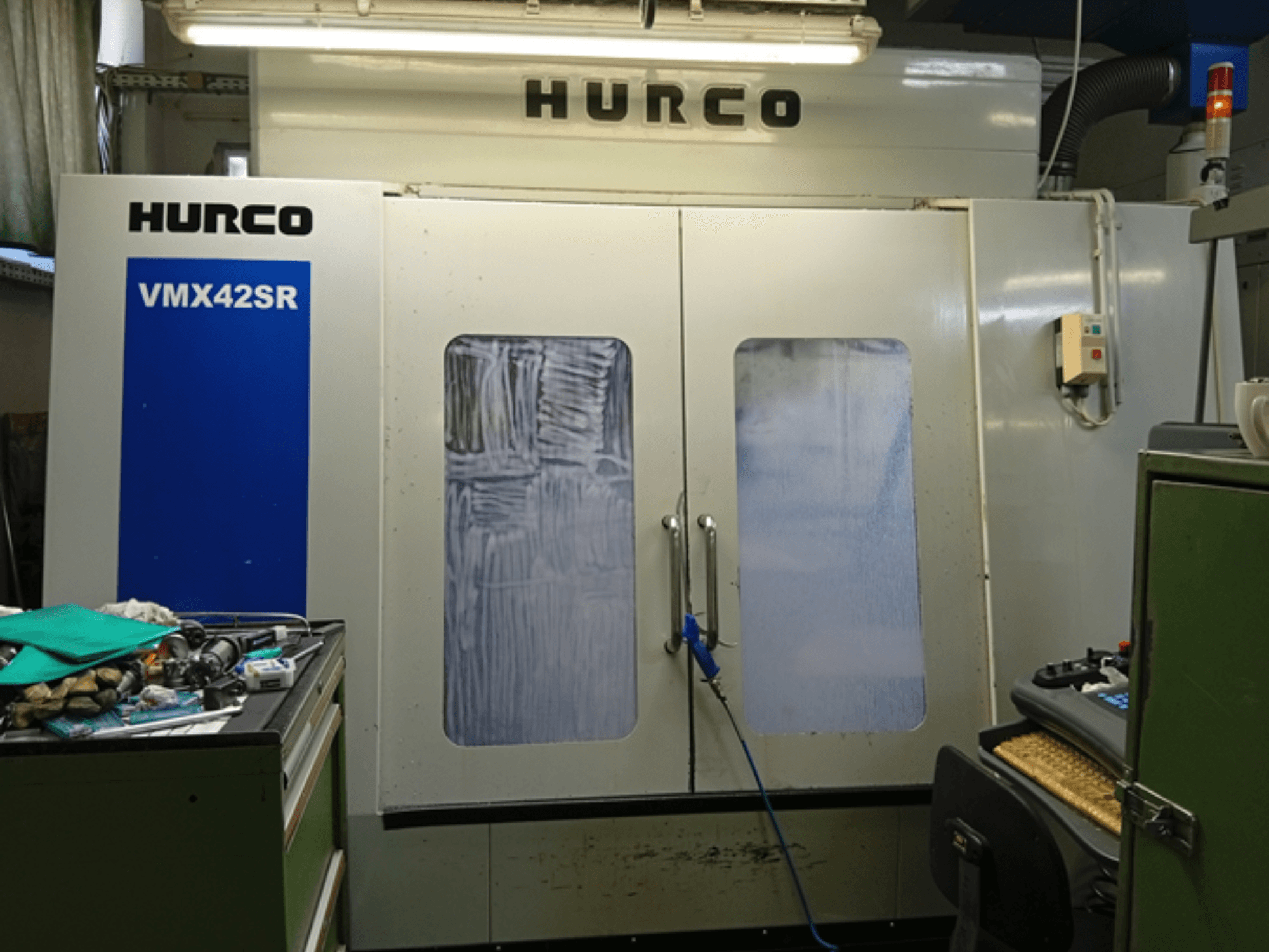 Hurco VMX 42SR verticaal bewerkingscentrum in vooraanzicht, met blauw paneel, bedieningsinterface en schone werkruimte.