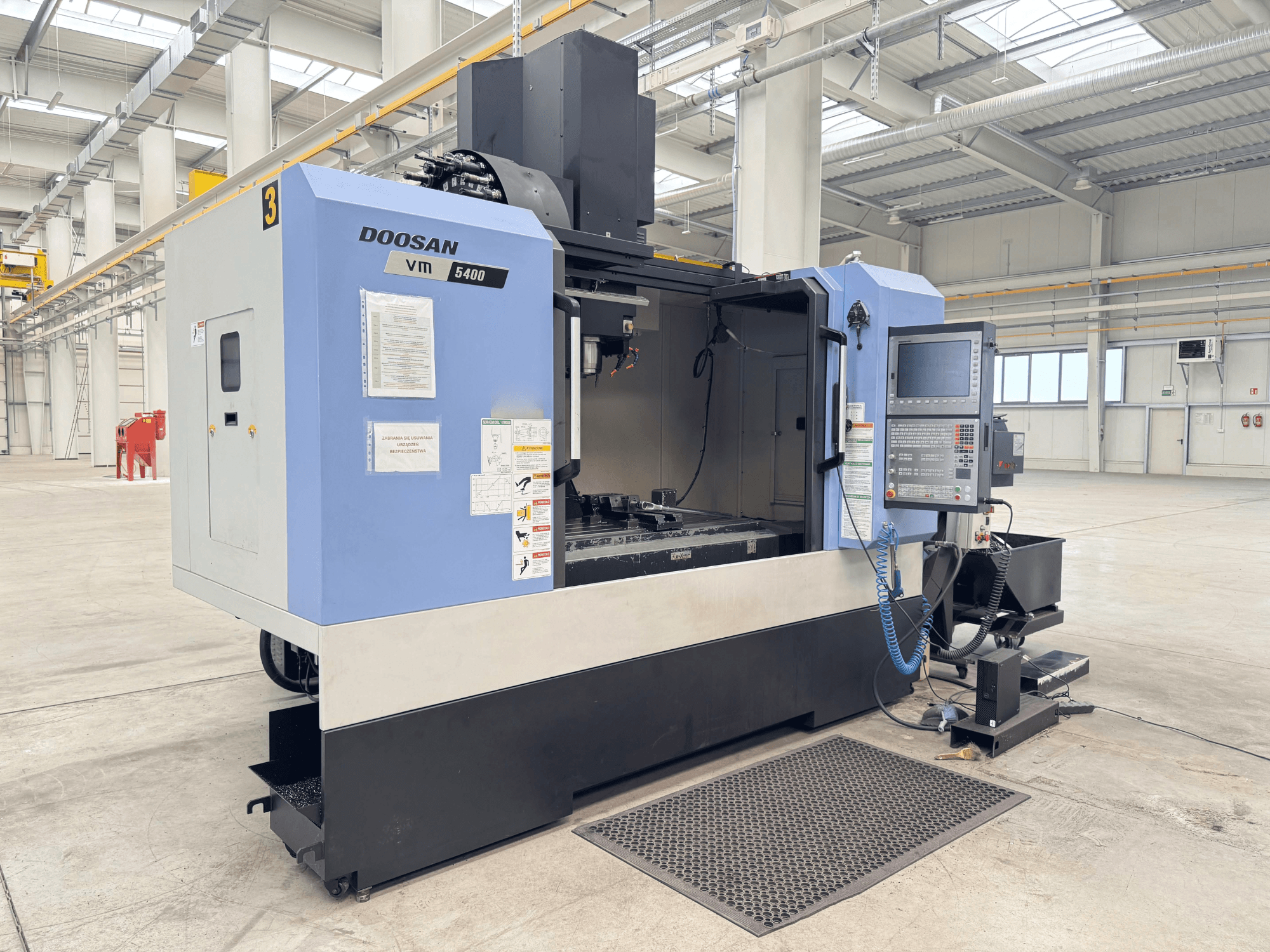 DOOSAN VM 5400 verticaal bewerkingscentrum, vooraanzicht met bedieningspaneel en werkgebied in ruime industriële omgeving.