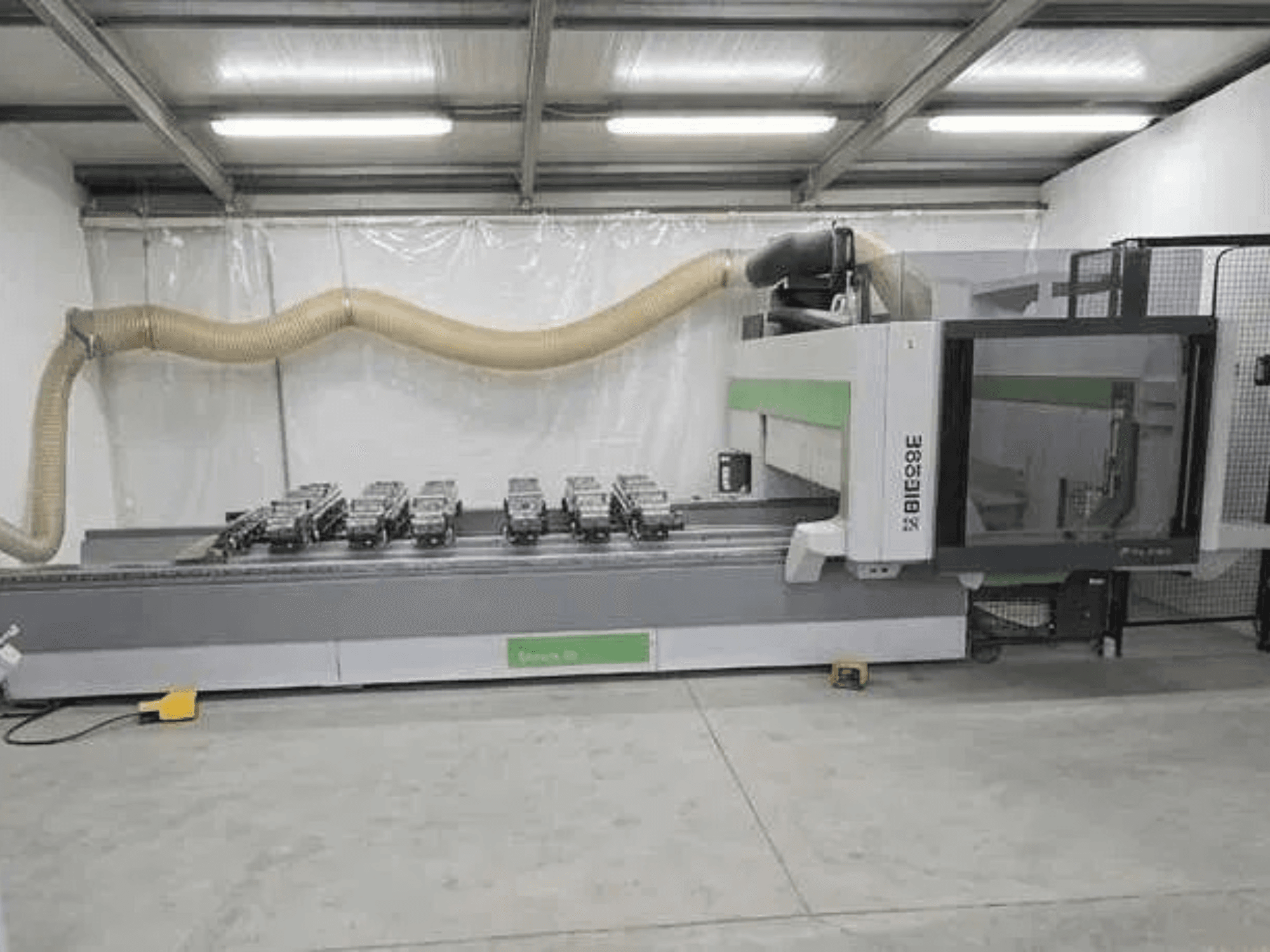 BIESSE Rover K1232 CNC-bewerkingscentrum in zijaanzicht, waarbij de vacuümzuignappen en het stofafzuigsysteem zichtbaar zijn.