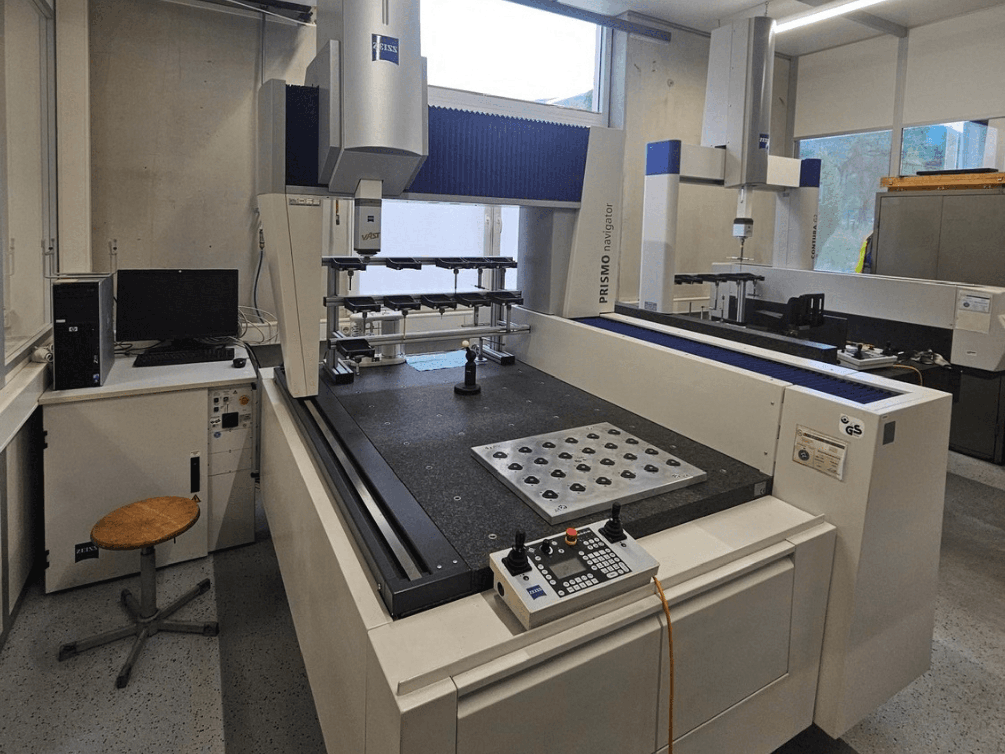 ZEISS Prismo Navigator 7 CMM in een laboratorium, vooraanzicht met bedieningspaneel, werktafel en monitor.