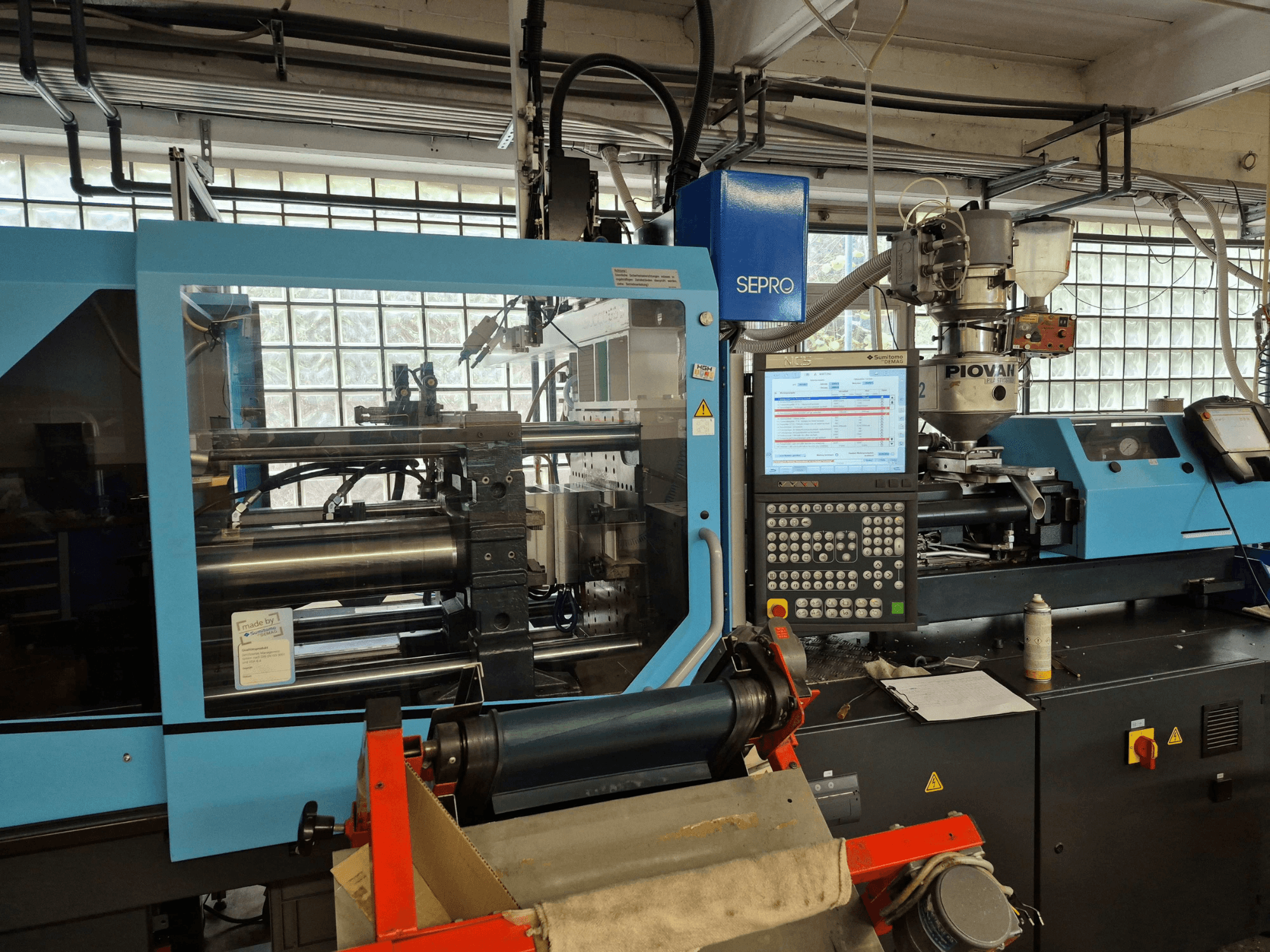 Hydraulische spuitgietmachine SUMITOMO SHI DEMAG Systec 120/470-430, vooraanzicht met zichtbaar bedieningspaneel en toevoersysteem.