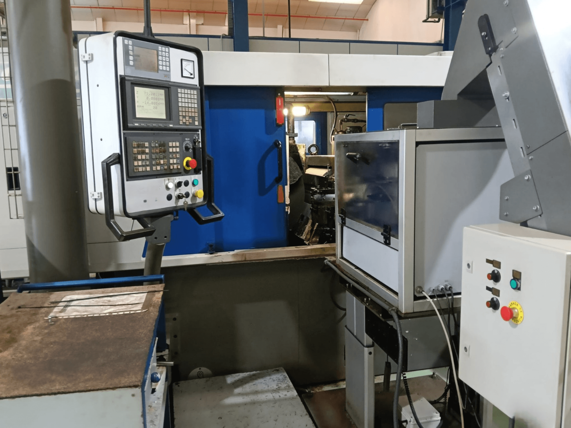 Bedieningspaneel en machines van de DANOBAT 327 MDA centerloze slijpmachine, gezien vanaf de zijkant, met knoppen en display.