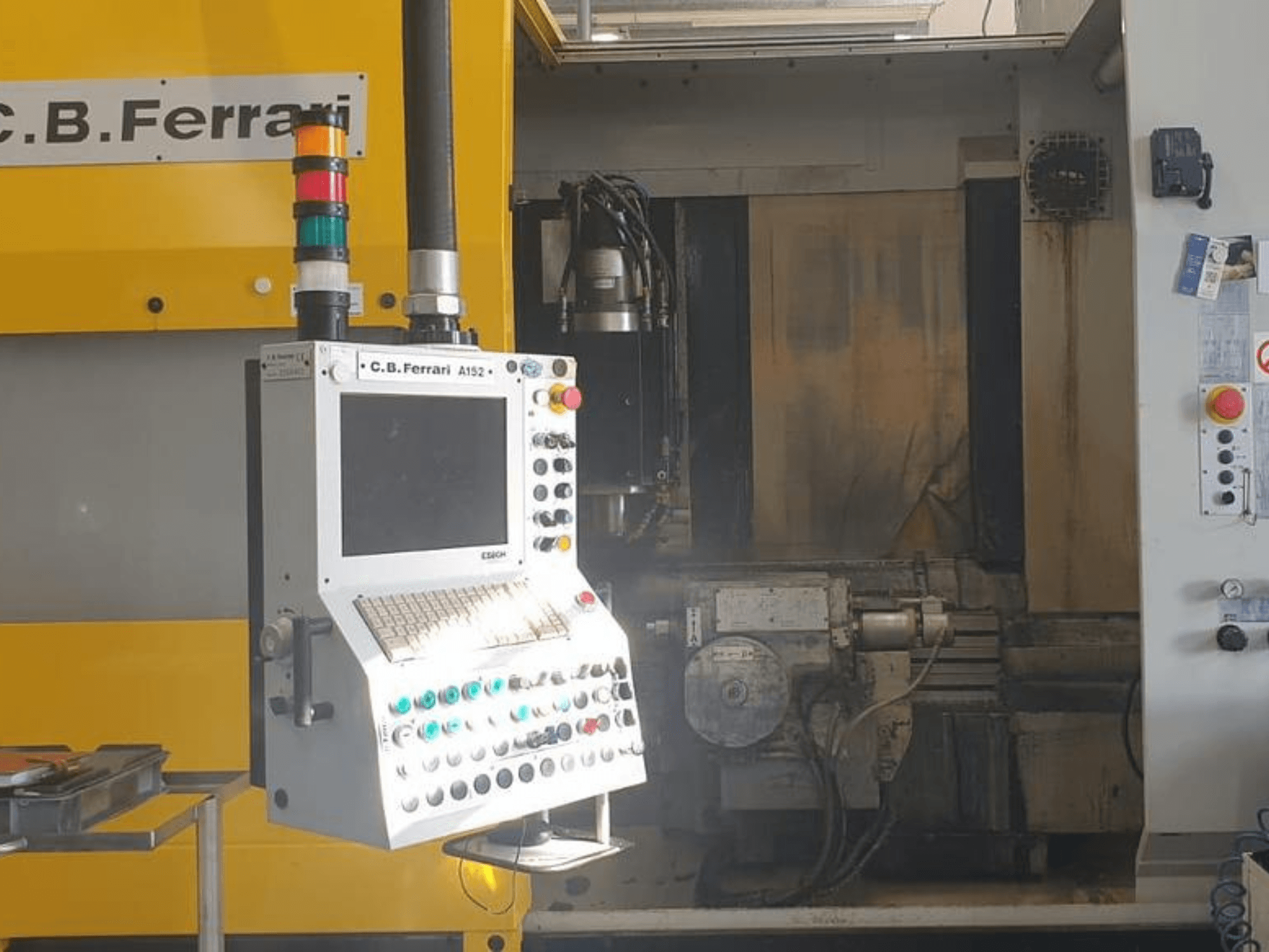 C.B. Ferrari A152 Verticaal Bewerkingscentrum vooraanzicht, met het bedieningspaneel met knoppen en motoronderdelen op de machine.