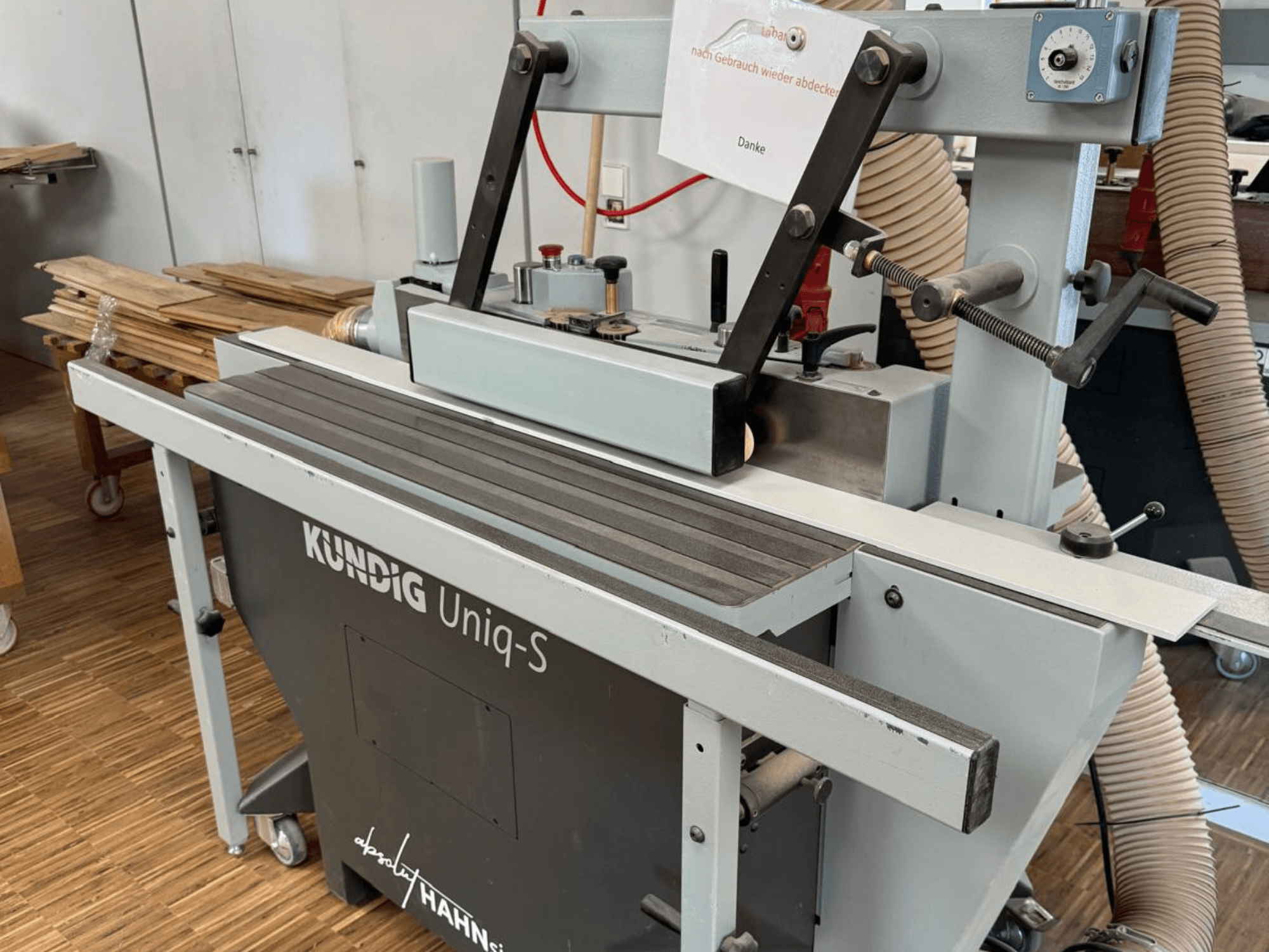 Kundig UNIQ-S bandschuurmachine in een werkplaats, zijaanzicht van de schuurband en verstelbare steunarmen.
