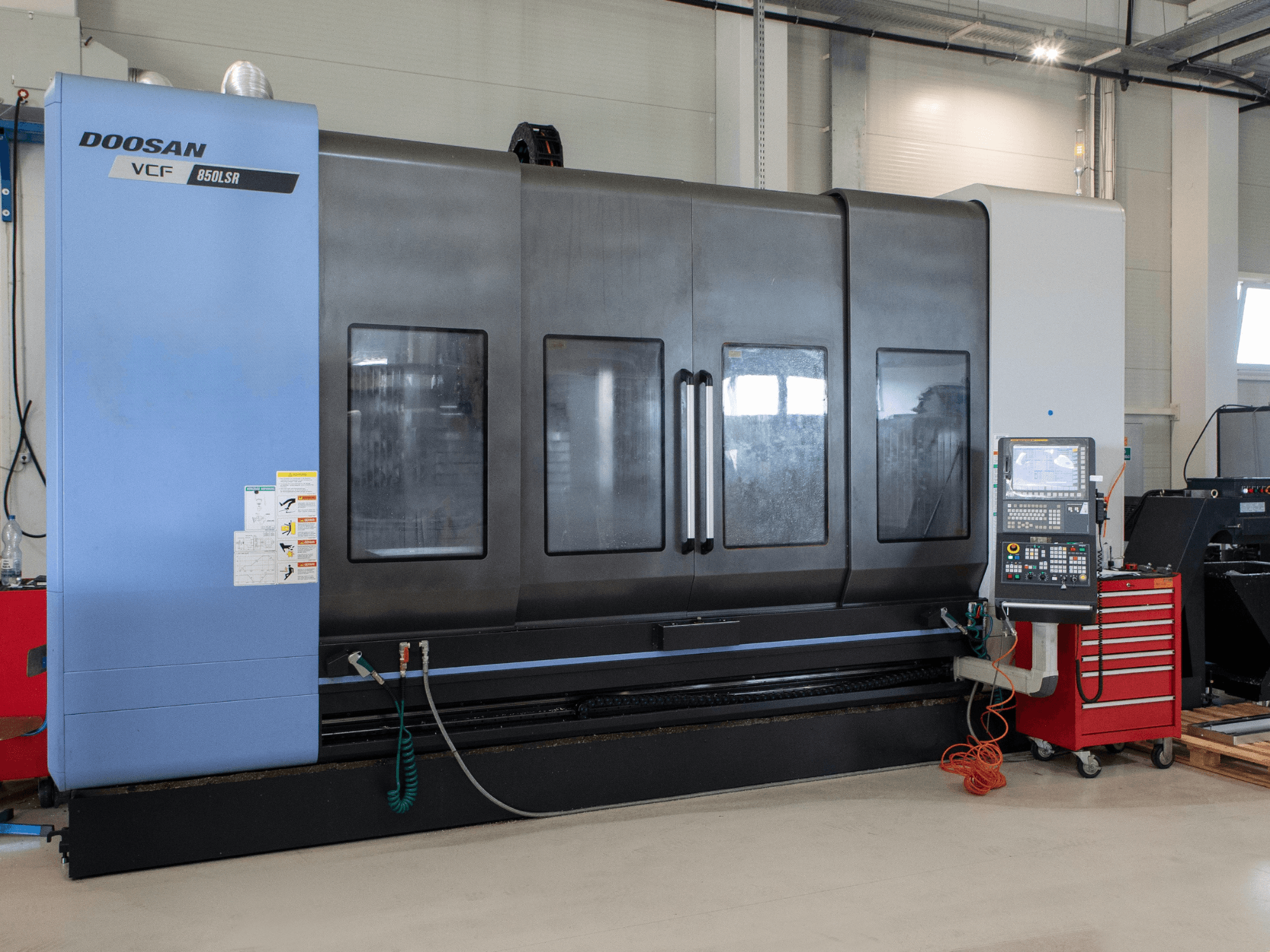 DOOSAN VCF850 frees- en draaicentrum, vooraanzicht; voorzien van grote dubbele ramen, bedieningspaneel en gereedschapopslag. Ideaal voor verspanen.